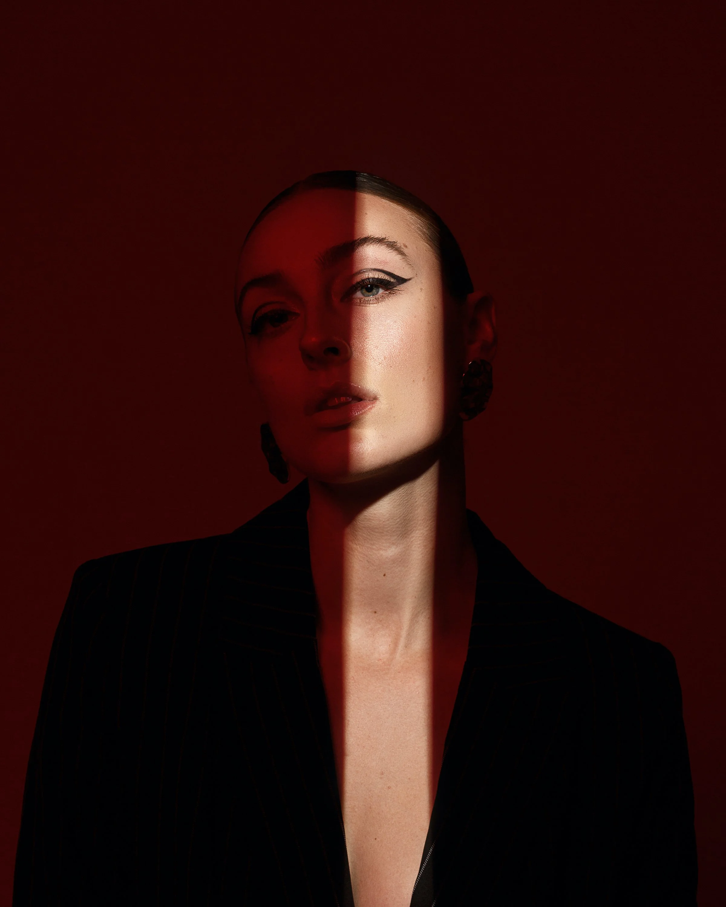 commercial portrait of model in black blazer using colored gel photography dramatic lighting