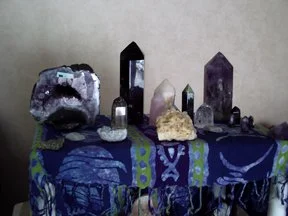 Collection of various crystals and gemstones displayed on a blue patterned cloth.