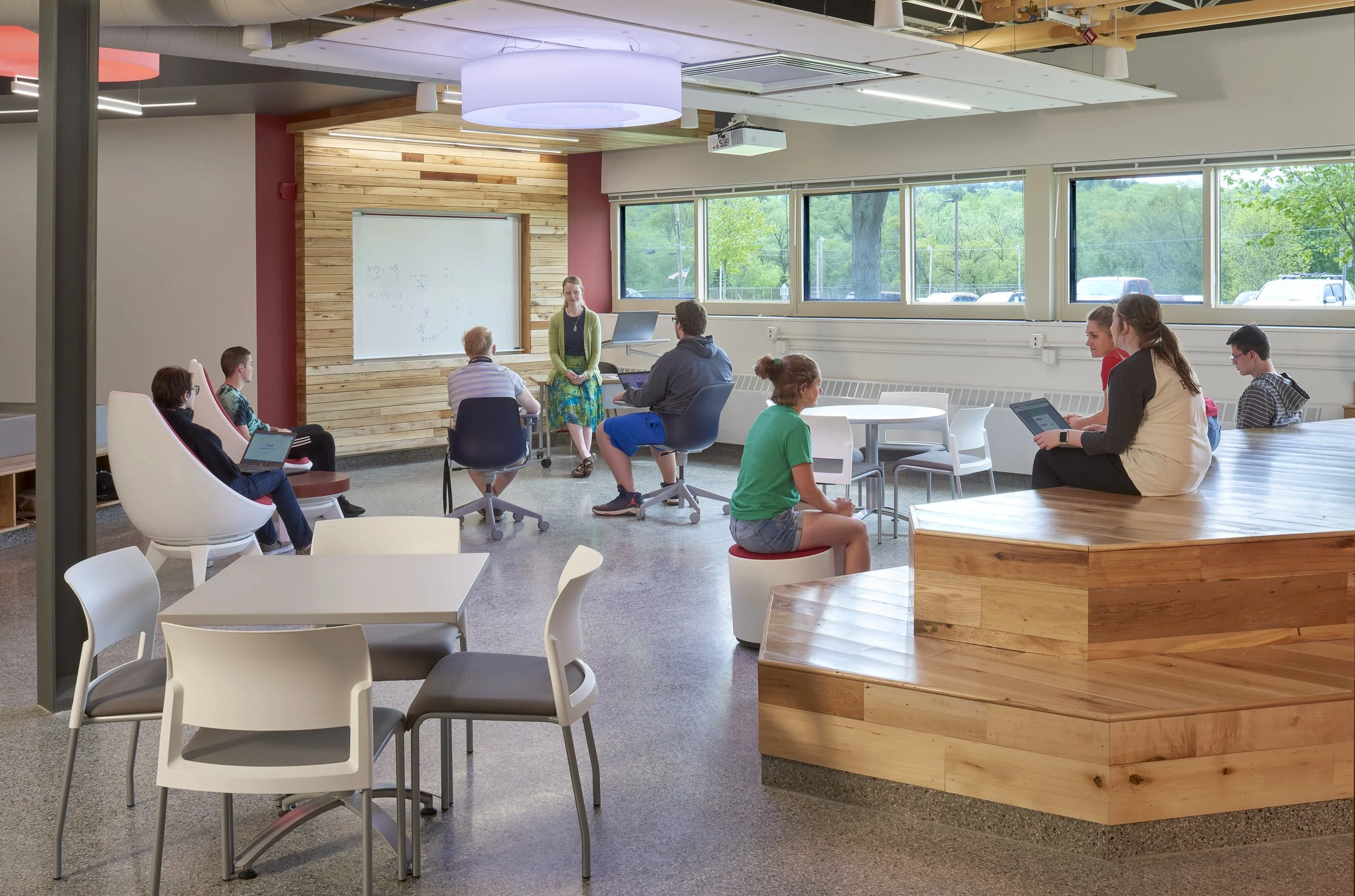Teacher leading a collaborative lesson in a flexible learning space with movable furniture and integrated technology.