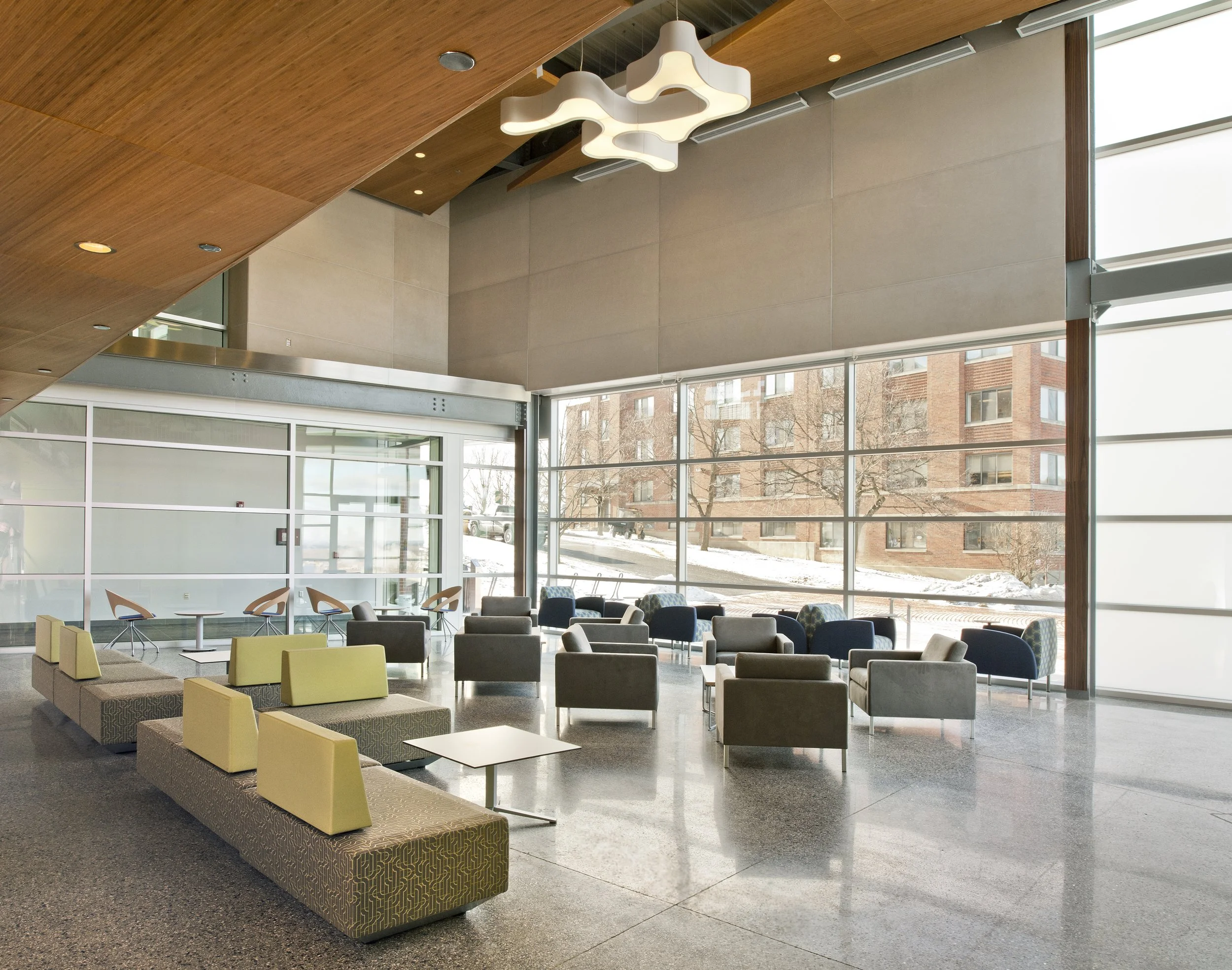 Two-story lobby with flexible lounge seating, floor-to-ceiling glazing, and collaborative gathering space.