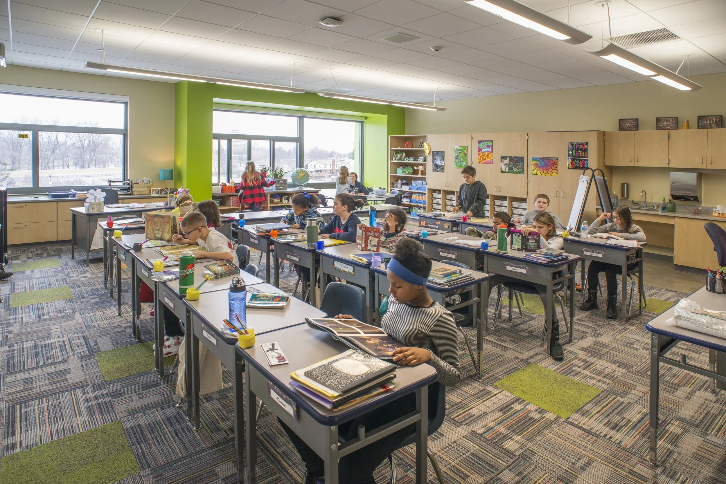 Daylit elementary classroom with flexible learning spaces, colorful finishes, and students engaged in classroom activities.
