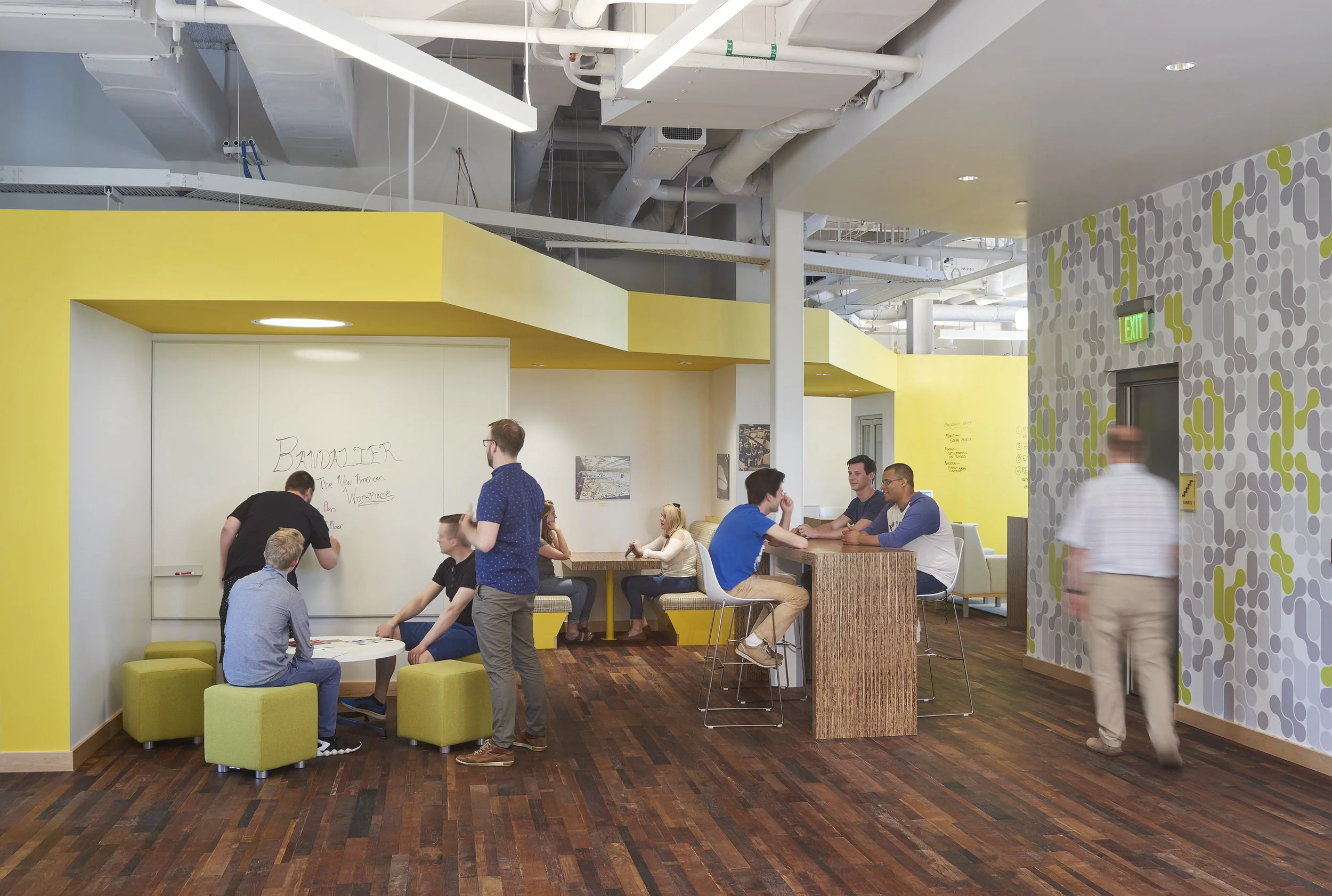 Flexible collaboration space with whiteboard walls, lounge seating, and informal meeting areas designed to encourage innovation and teamwork.