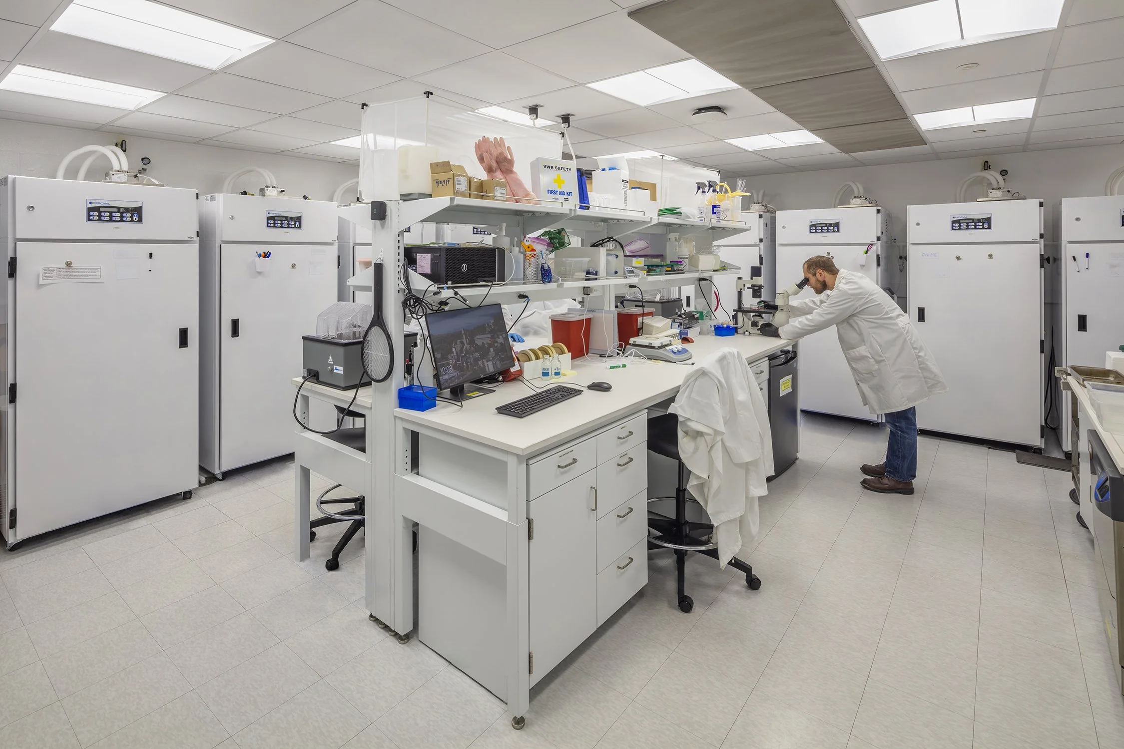 Researcher using a microscope in a Cornell University laboratory.