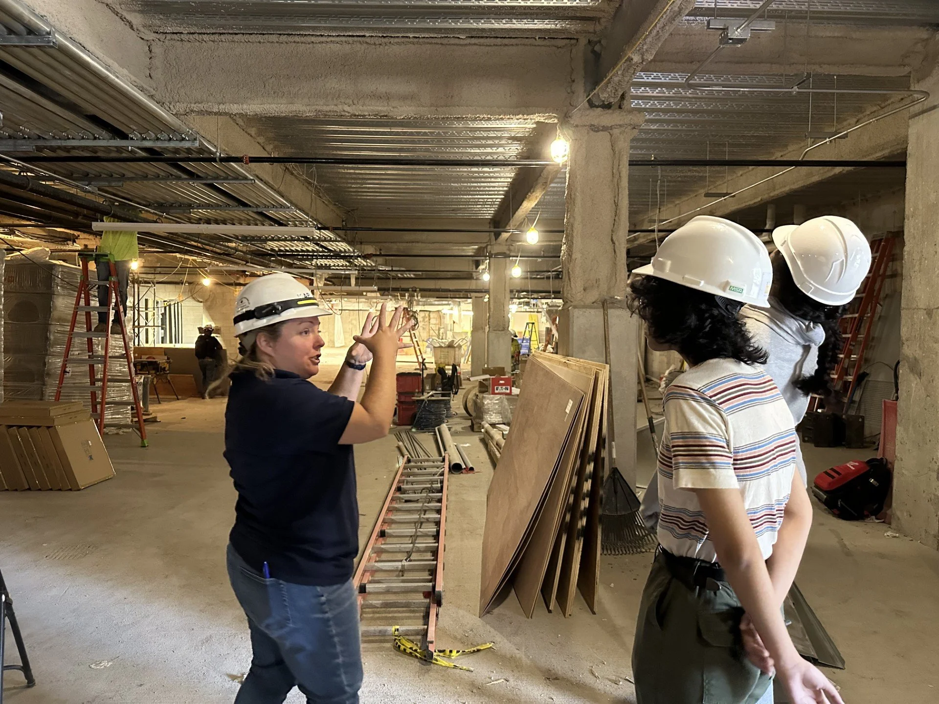 A member from Kaplan Construction leading high school students on a construction site tour.