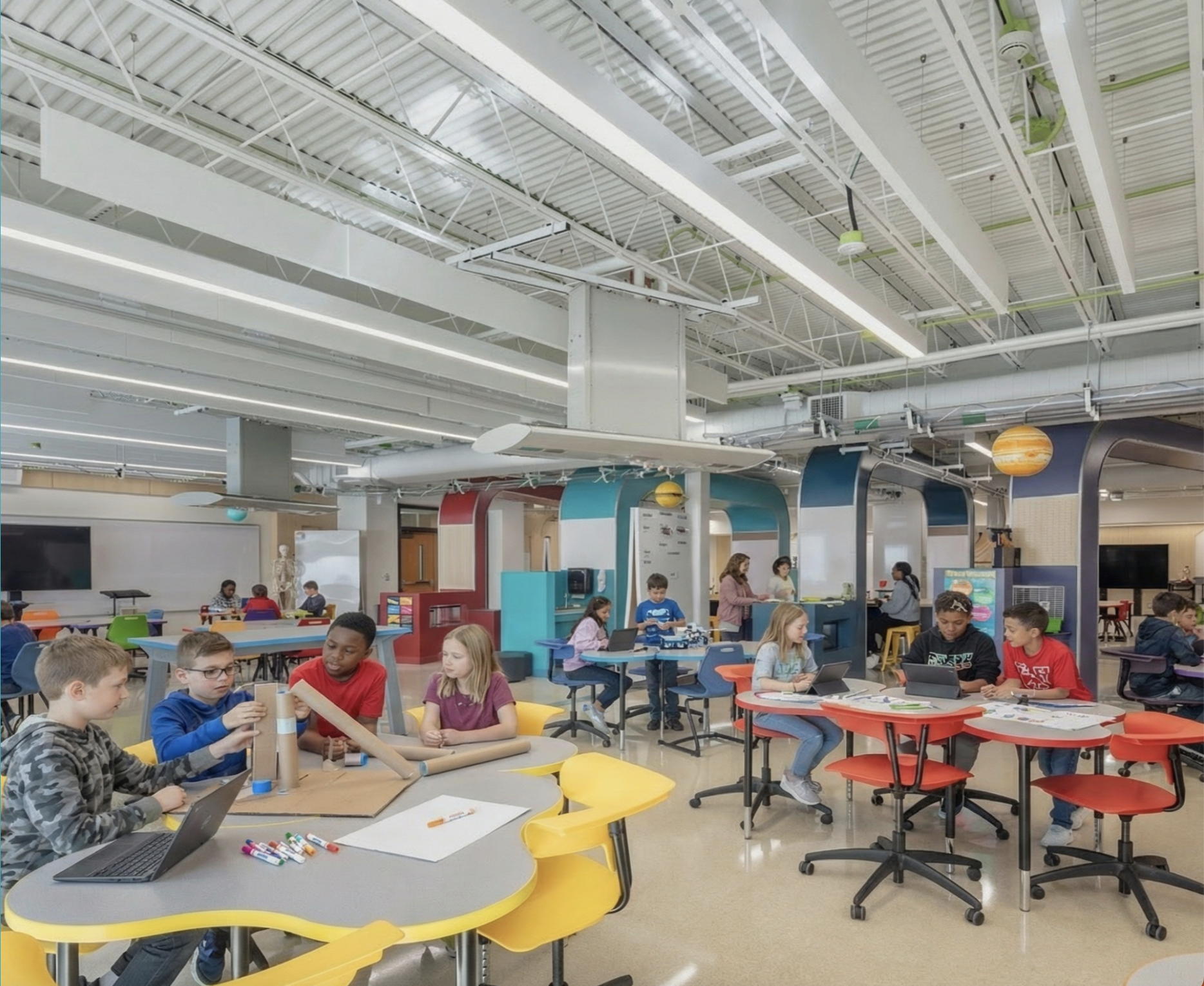 Photograph of students collaborating at tables in a classroom with bright colors