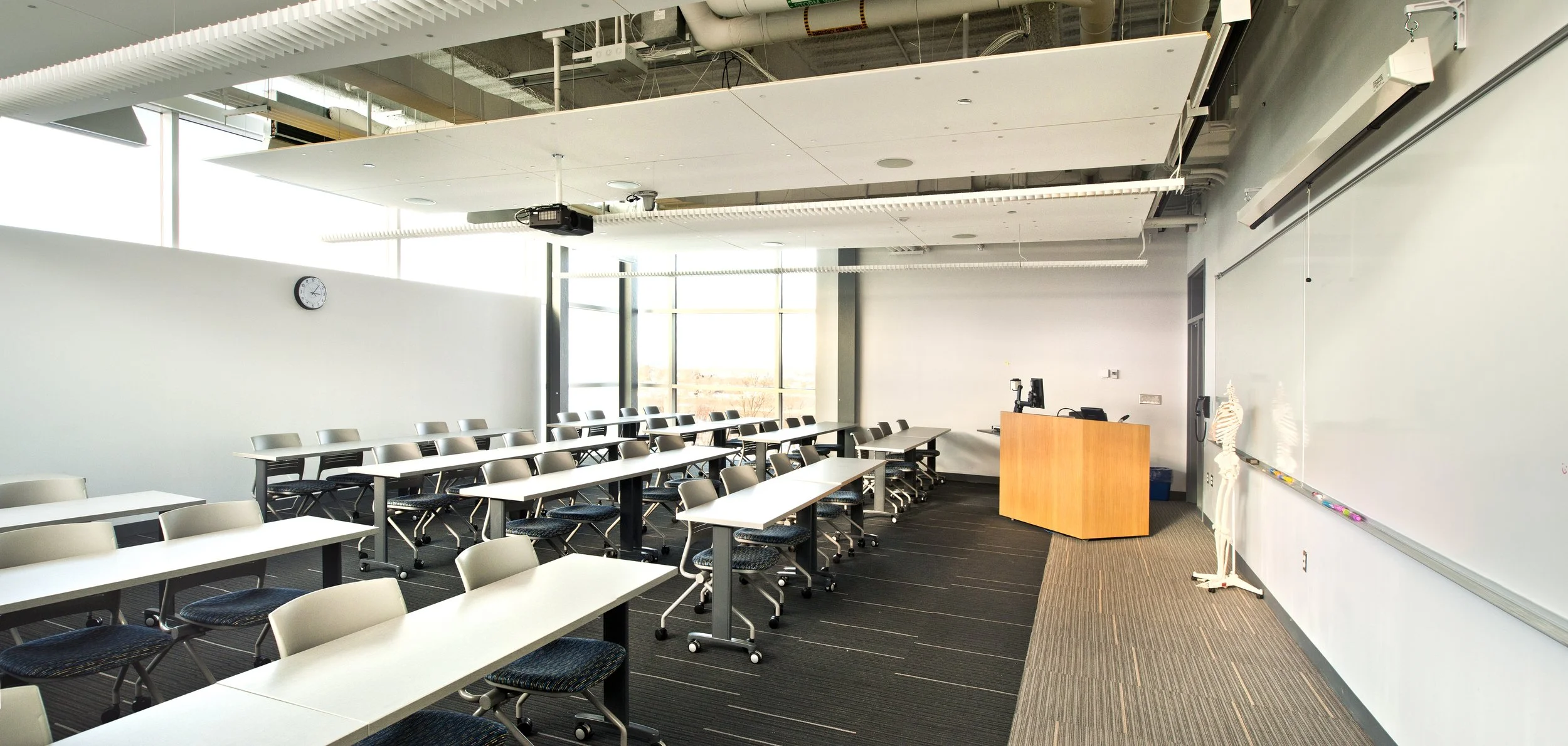 Flexible classroom in the Le Moyne College Coyne Science Center Addition with movable tables, integrated technology, floor-to-ceiling windows, and a large writable wall.