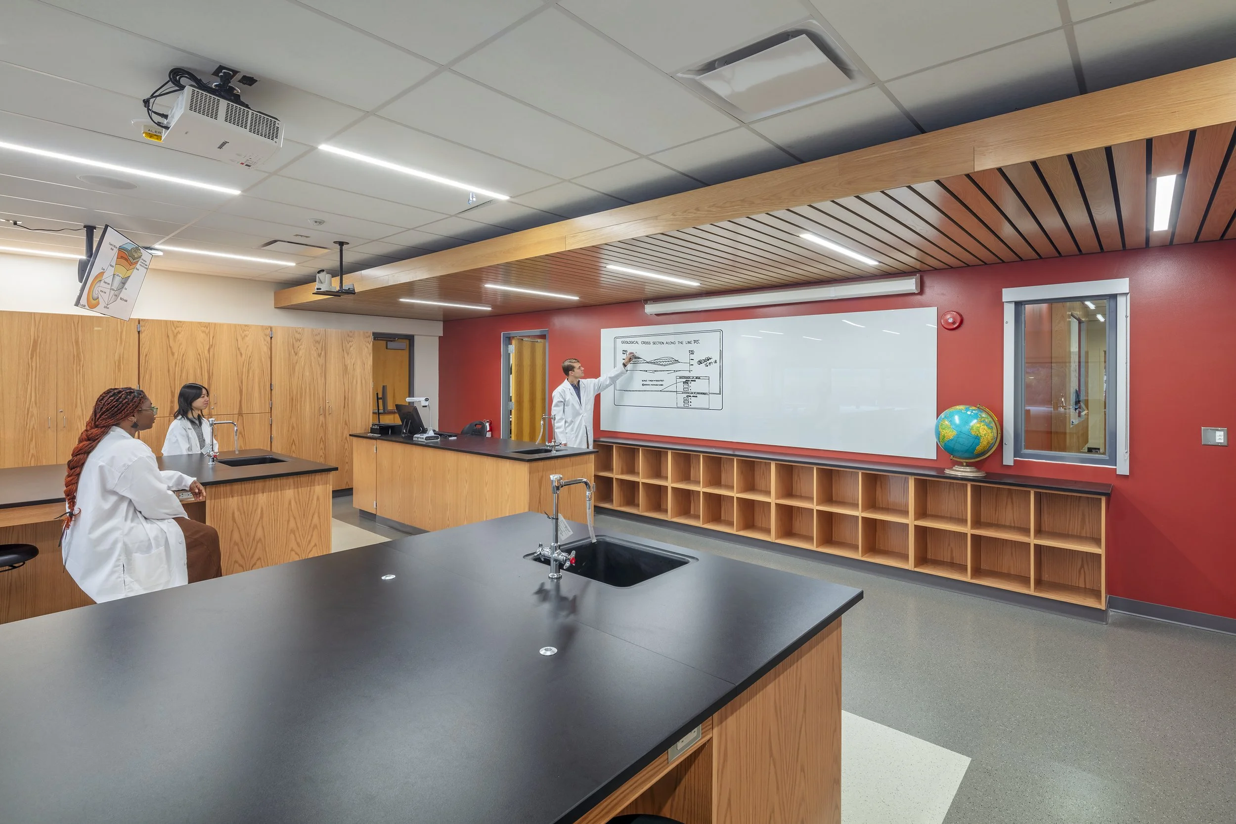 Science laboratory classroom with demonstration stations, lab sinks, integrated technology, and wood cabinetry.