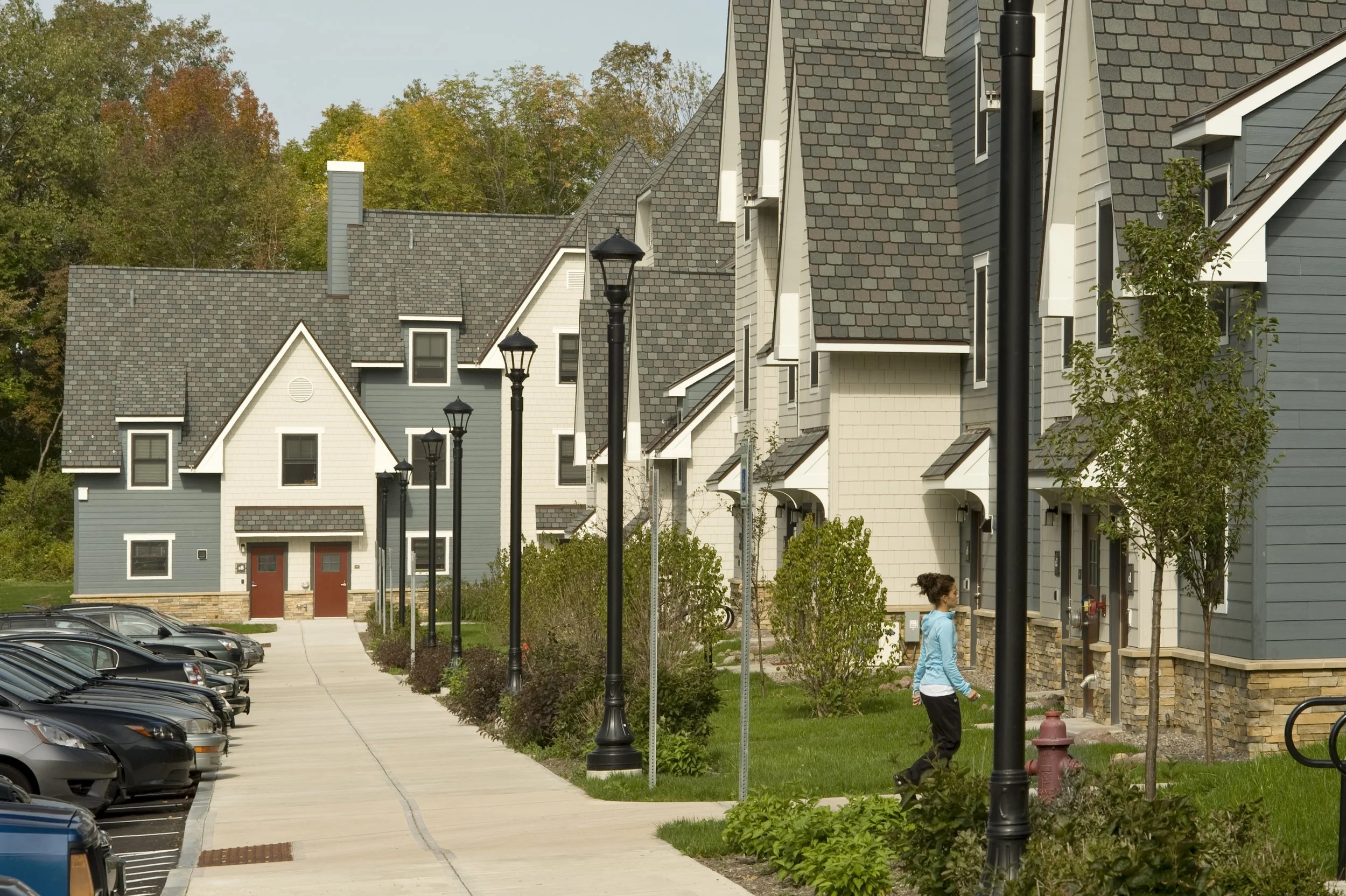 Multi-family apartment buildings with landscaped sidewalks, street lighting, parking, and pedestrian-friendly walkways.