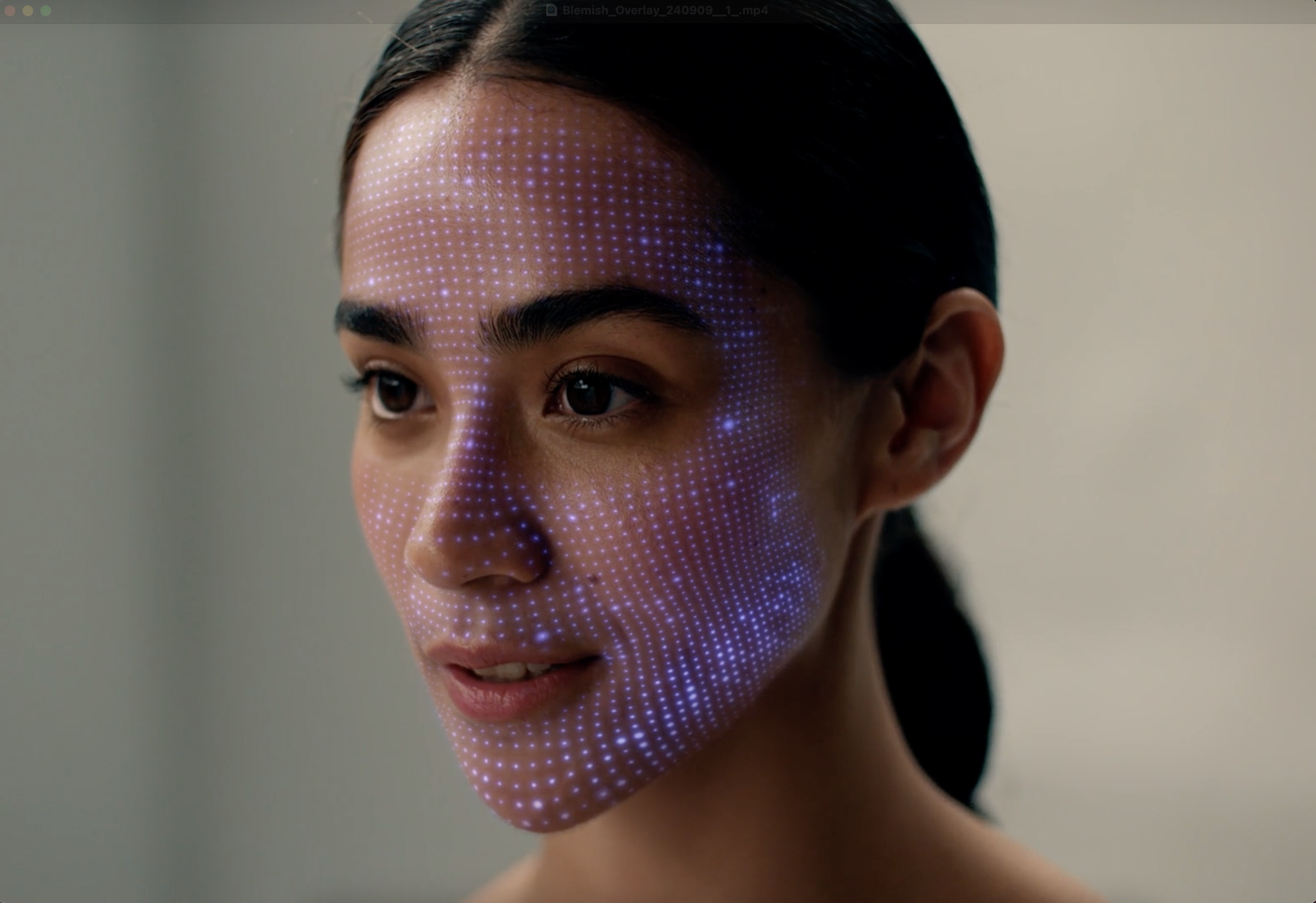 Close-up of a woman's face with digital overlay points, highlighting her facial features.
