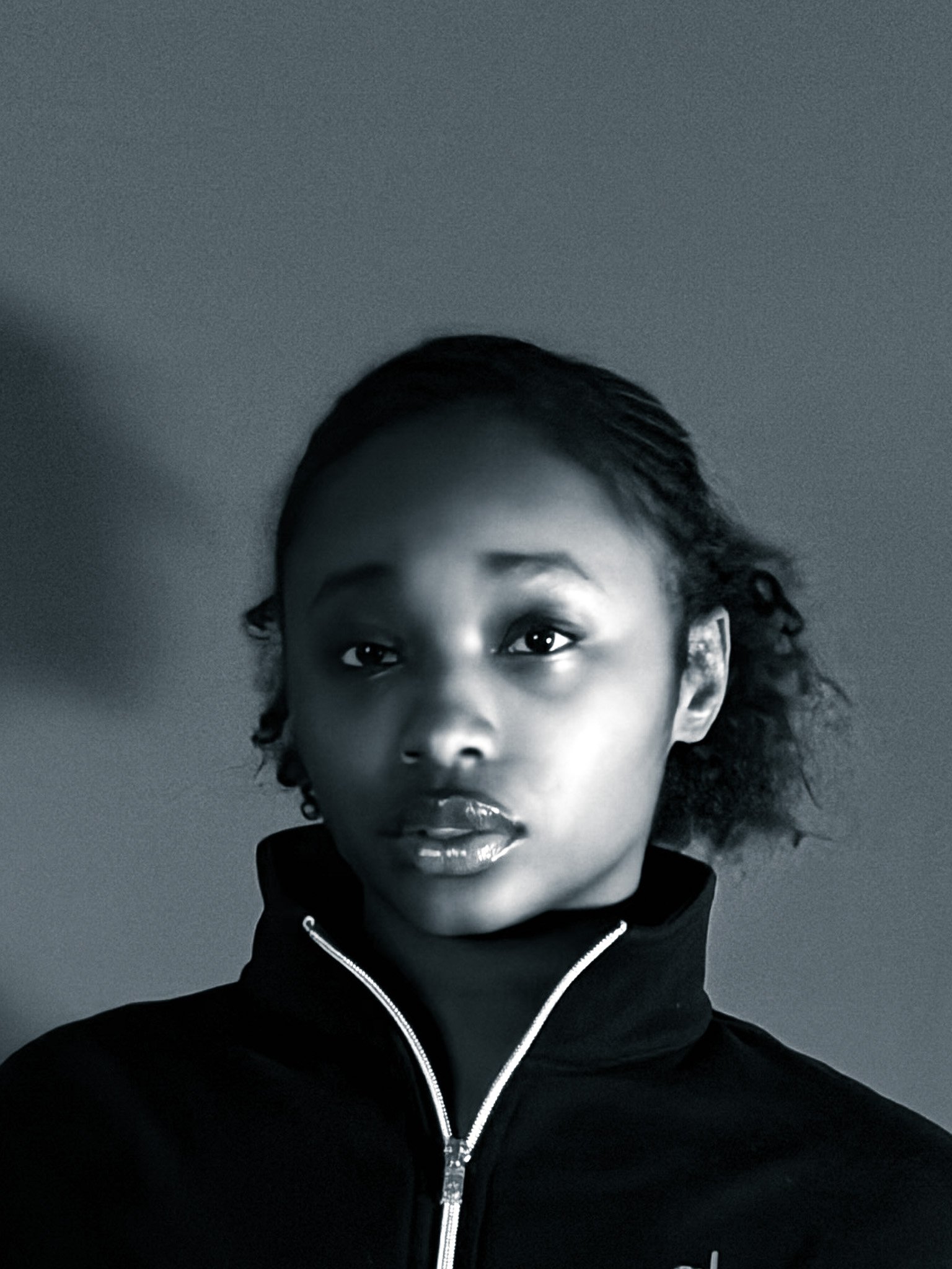 Black and white portrait of a young woman looking directly at the camera.