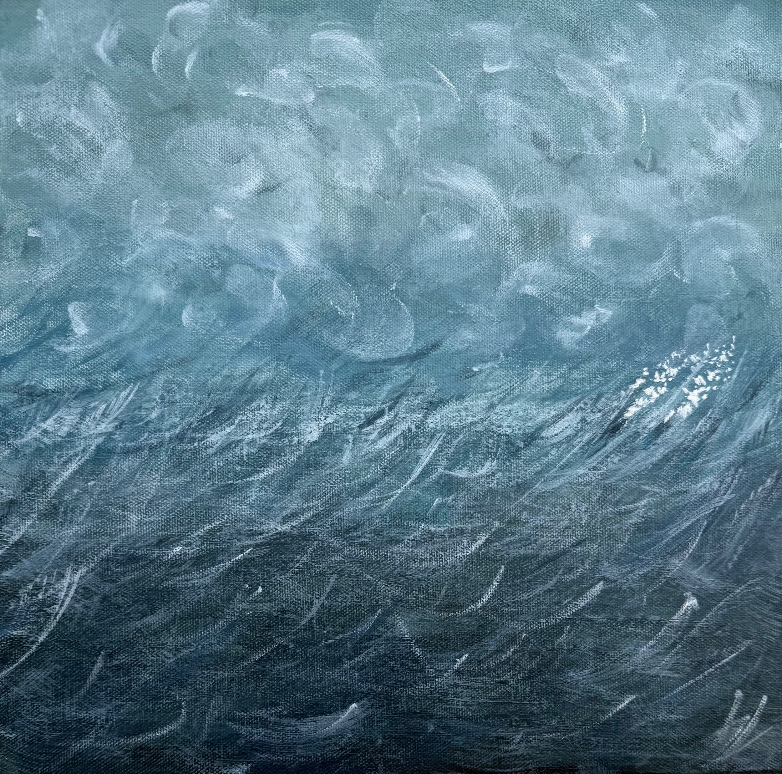 An aerial view of the ocean showing waves and water ripples.