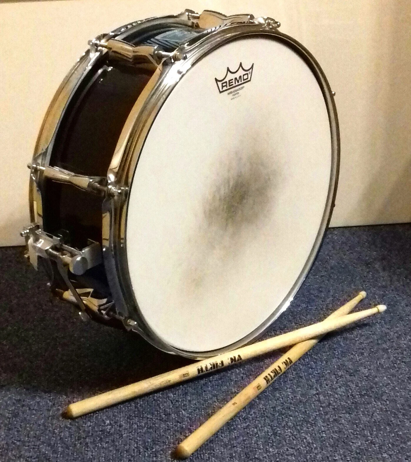 Eine Snare mit Trommelstöcken daneben