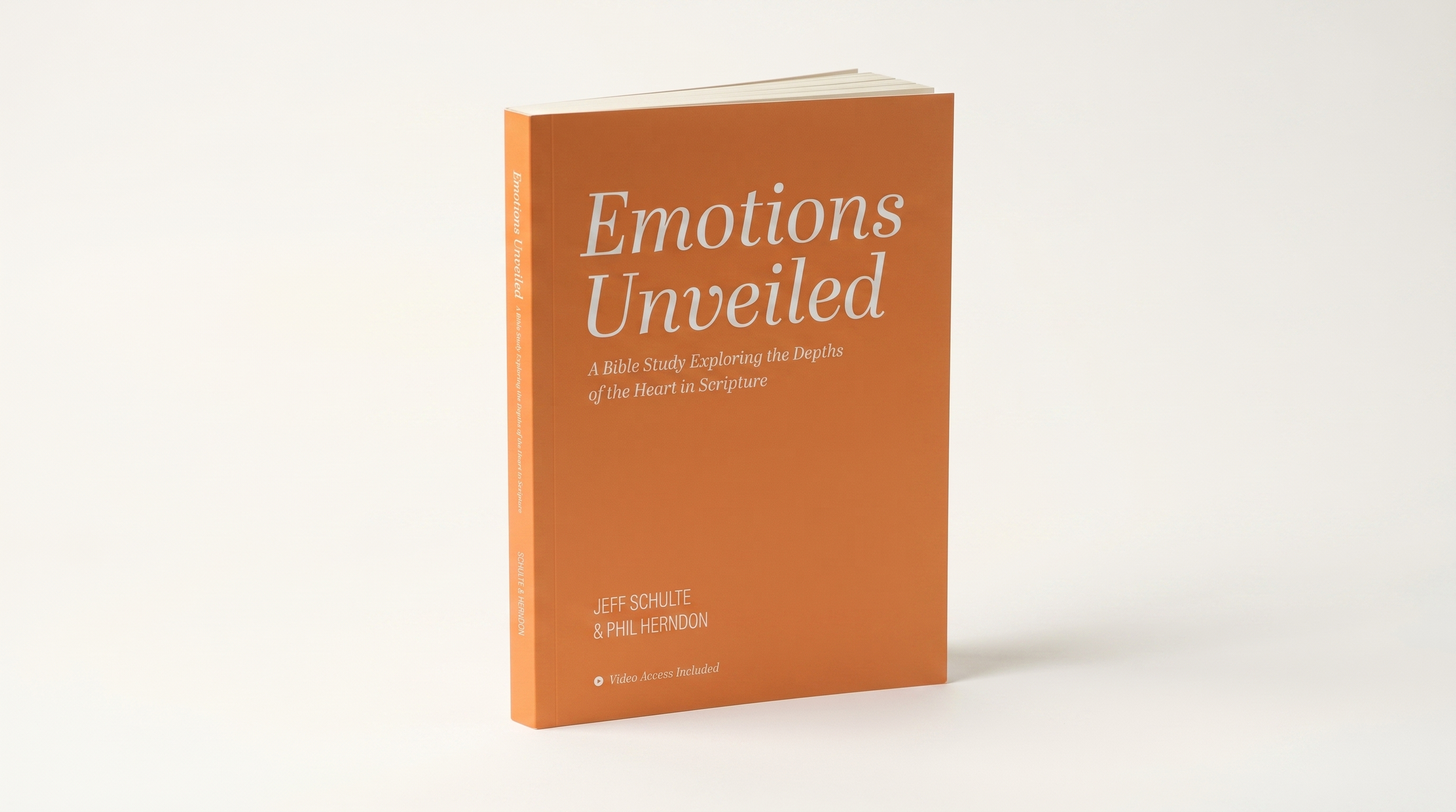 A book titled 'Emotions Unveiled' by Jeff Schulte and Phil Herndon, with a subtitle about exploring the depths of the heart in scripture, standing upright on a plain surface, against a plain white background.
