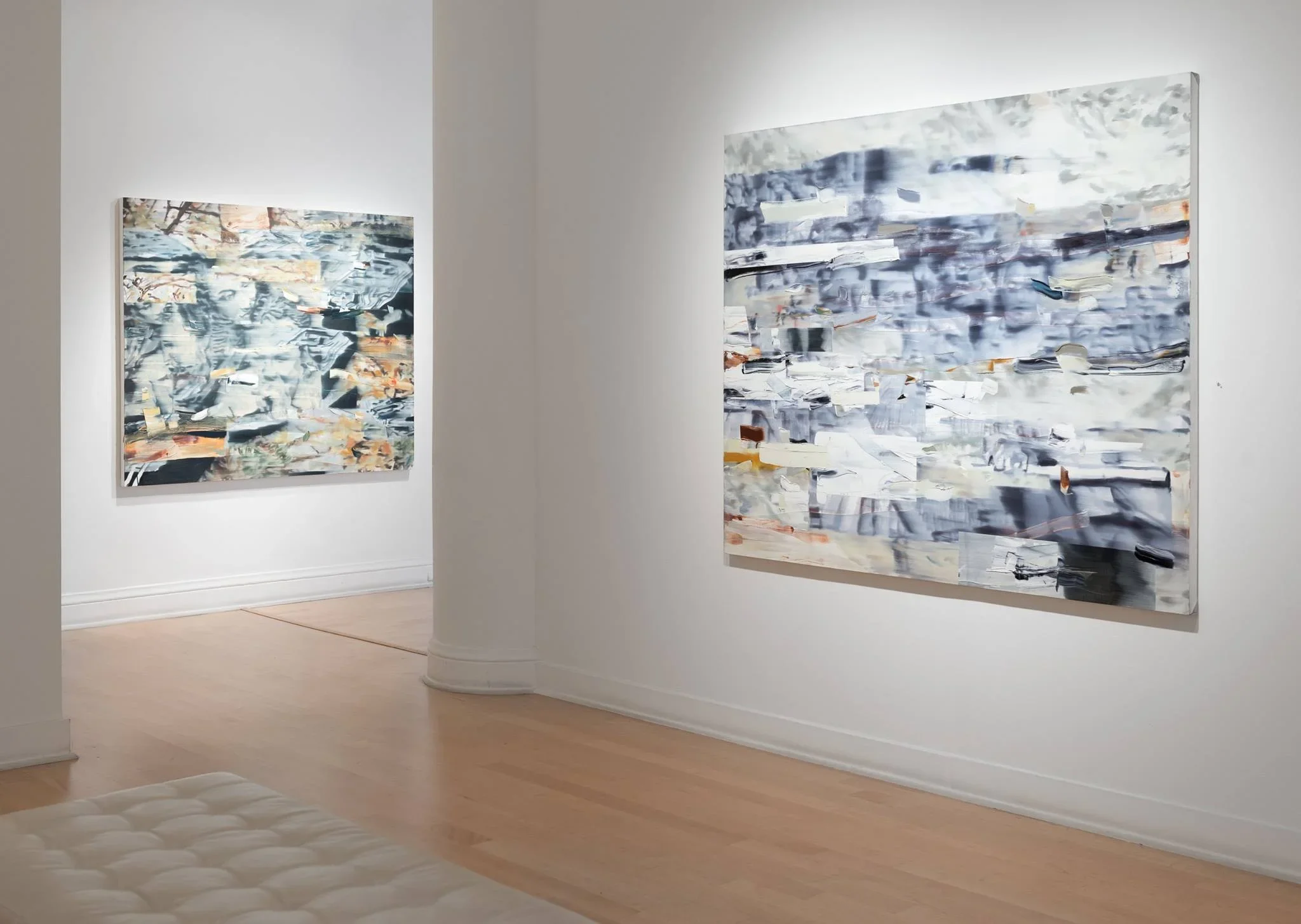Two large abstract paintings displayed on white gallery walls in a contemporary art gallery with a wood floor.