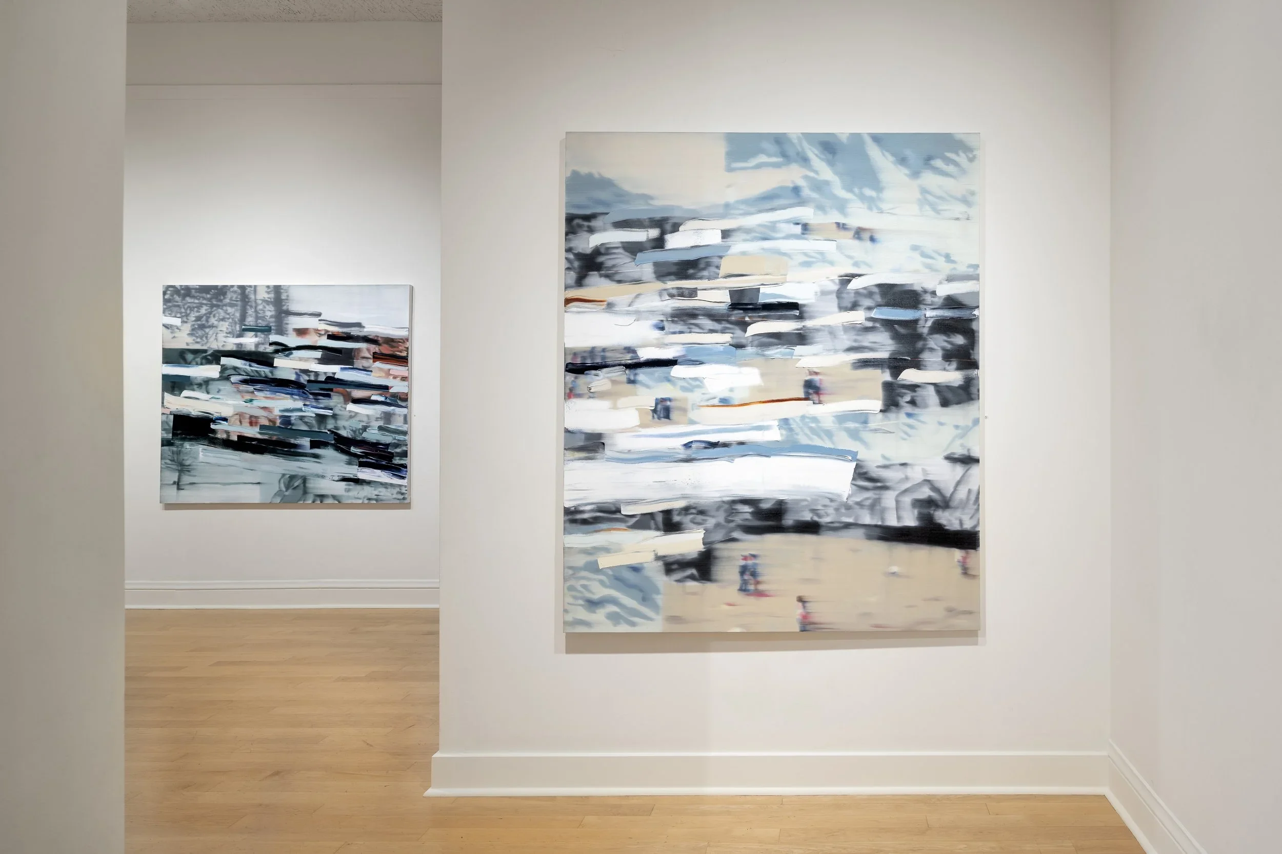 Two abstract paintings with swirling brushstrokes and a mix of blue, black, white, and beige colors hang on a white gallery wall.