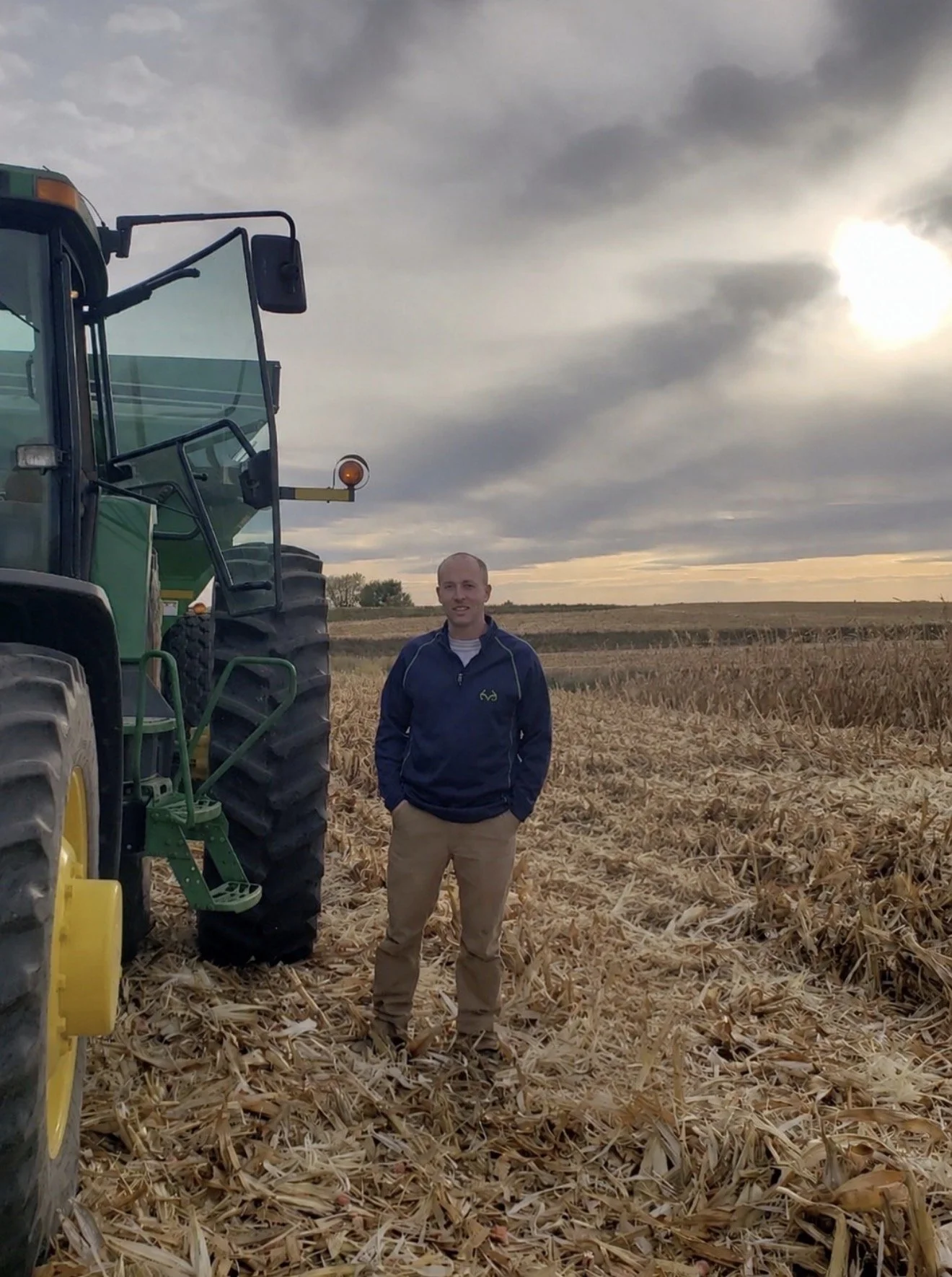Ben Lundgren standing in a harvested cornfield, reflecting his agricultural background and commitment to helping farmers make informed financial decisions.