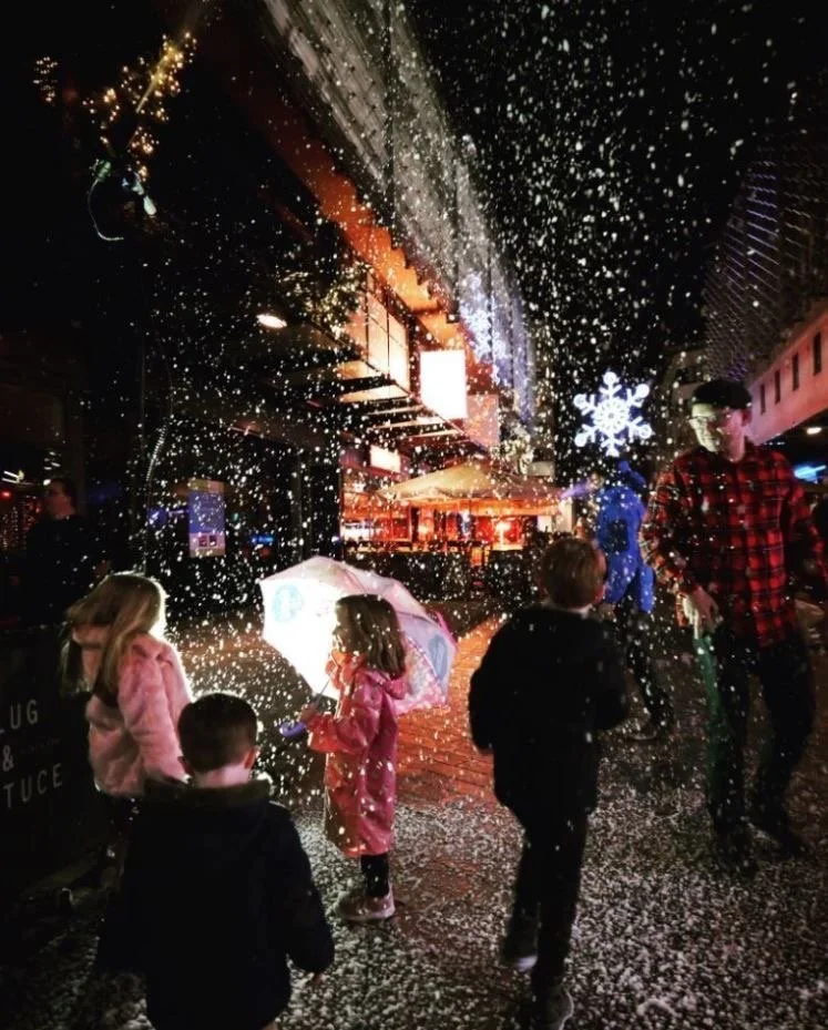 People walking in a city centre with realistic falling snow effects.
