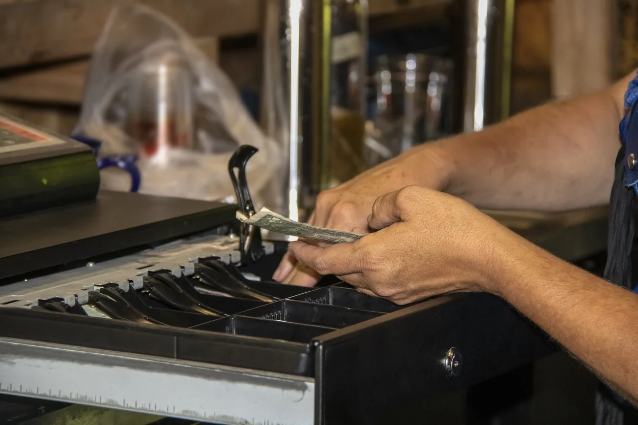 Hands taking cash out of a register