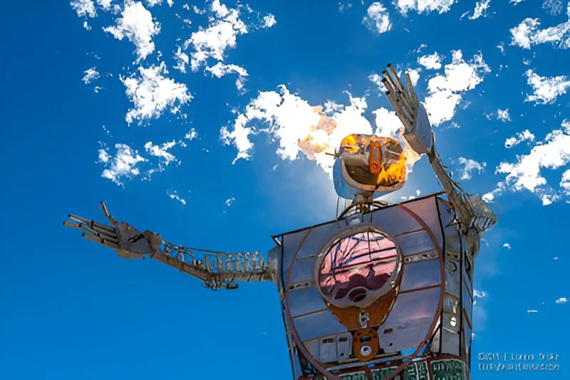 Metal statue against a blue sky with clouds