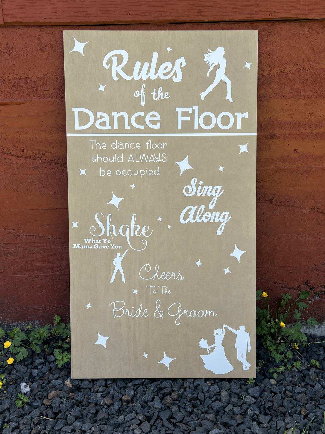 A decorative sign with dance floor rules for a wedding or event, including instructions to sing along, shake what your mama gave you, and cheers to the bride and groom, featuring silhouettes of dancers and stars.