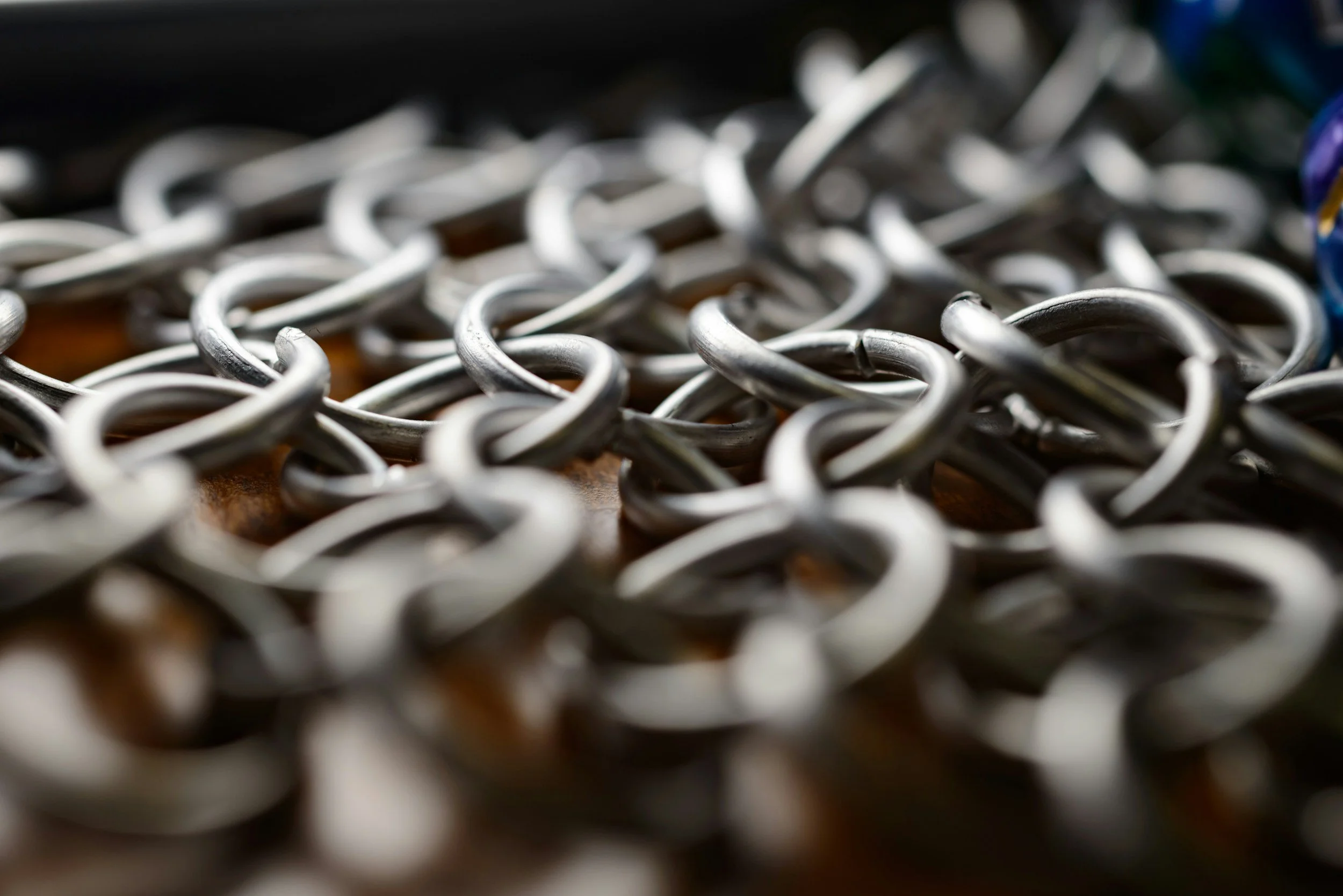 Close-up of intertwined metal hooks or rings, possibly part of chainmail, symbolic of the Knight way of thinking and Iron LIfe Health, or Ferrum Vitae