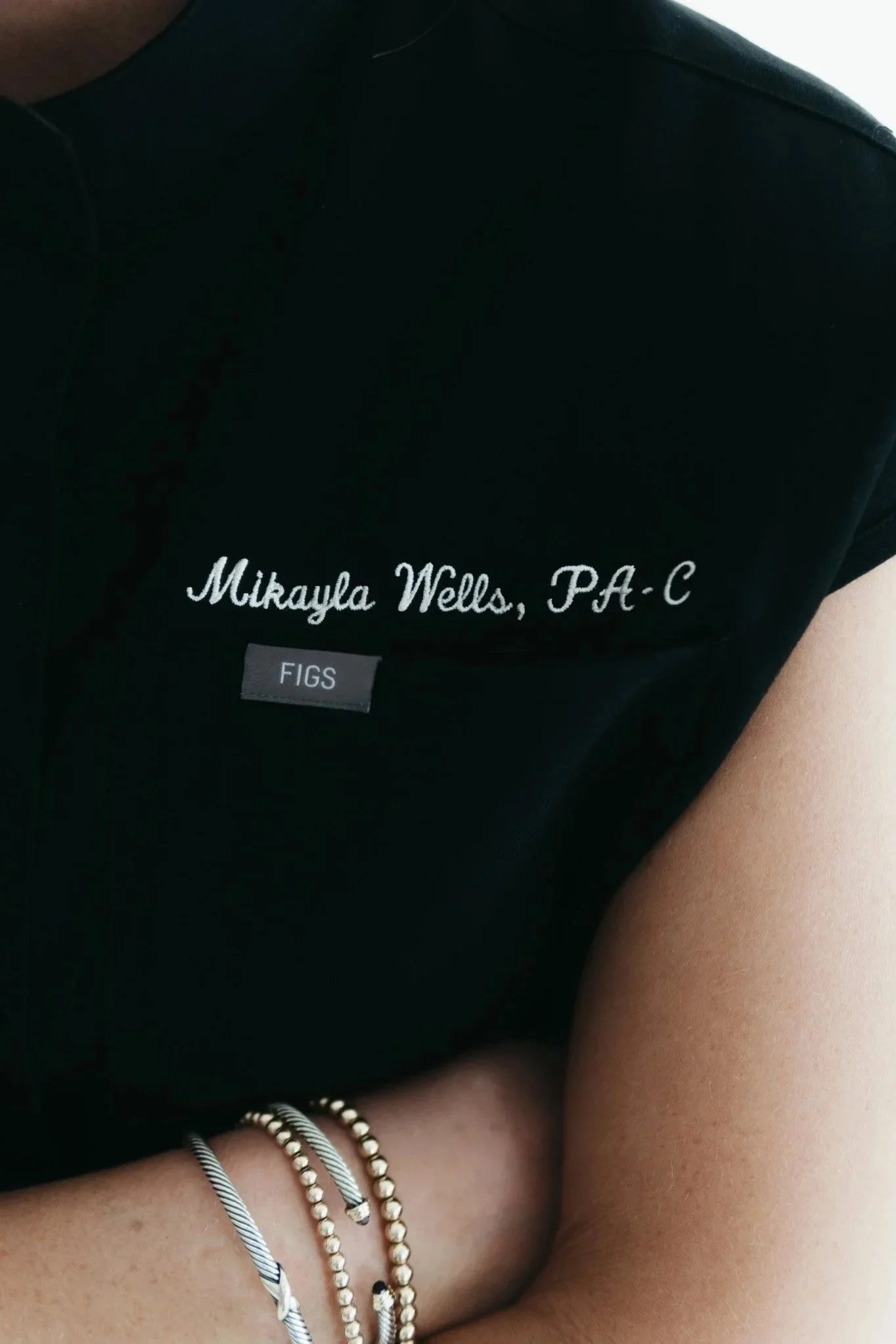 Close-up of Mikayla Wells, PA-C’s embroidered scrubs showing her name and credentials at Southwest Aesthetics+ in Lawton, OK