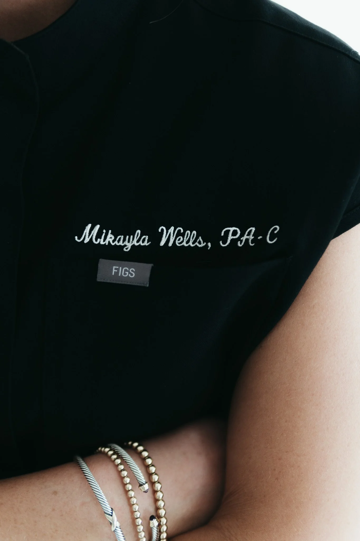 Close-up of Mikayla Wells, PA-C’s embroidered scrubs showing her name and credentials at Southwest Aesthetics+ in Lawton, OK