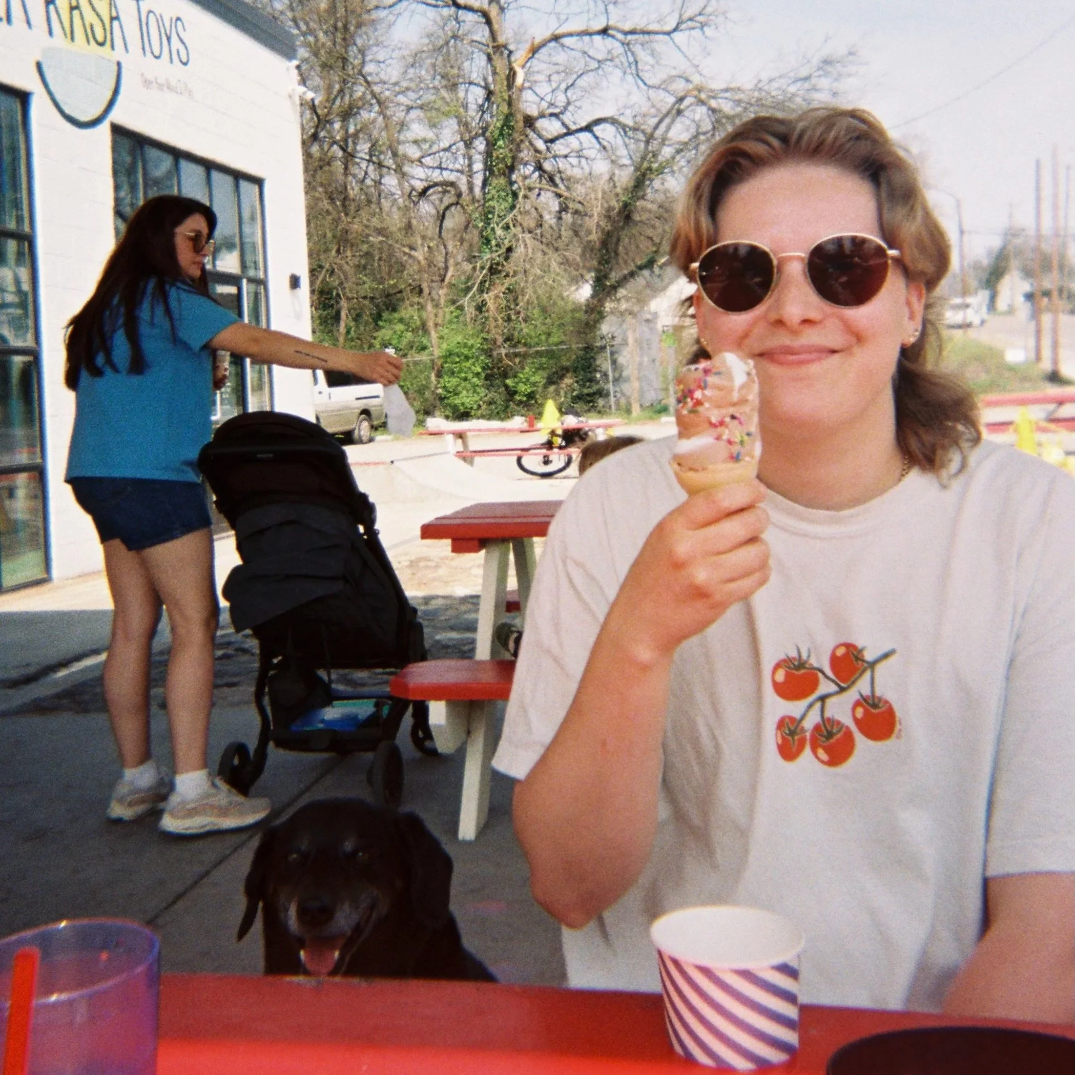 Nonbinary trans queer neurodivergent autistic adhd therapist smiling and looking at camera while holding up an ice cream cone taken on film camera in Nashville Tennessee (TN).
