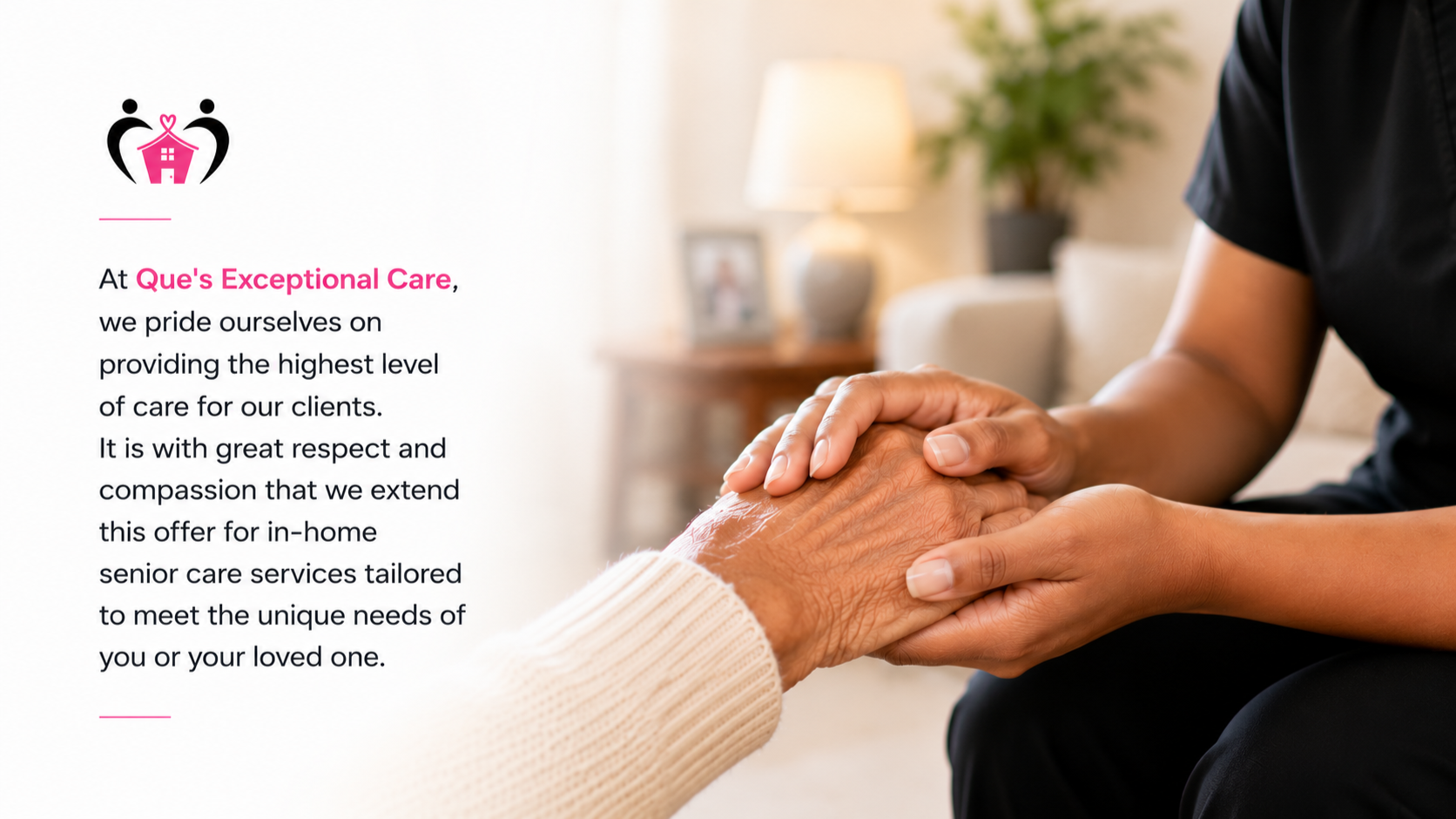 A caregiver softly holding an elderly person's hand in a cozy, well-lit living room with a lamp, framed photo, and houseplant in the background.