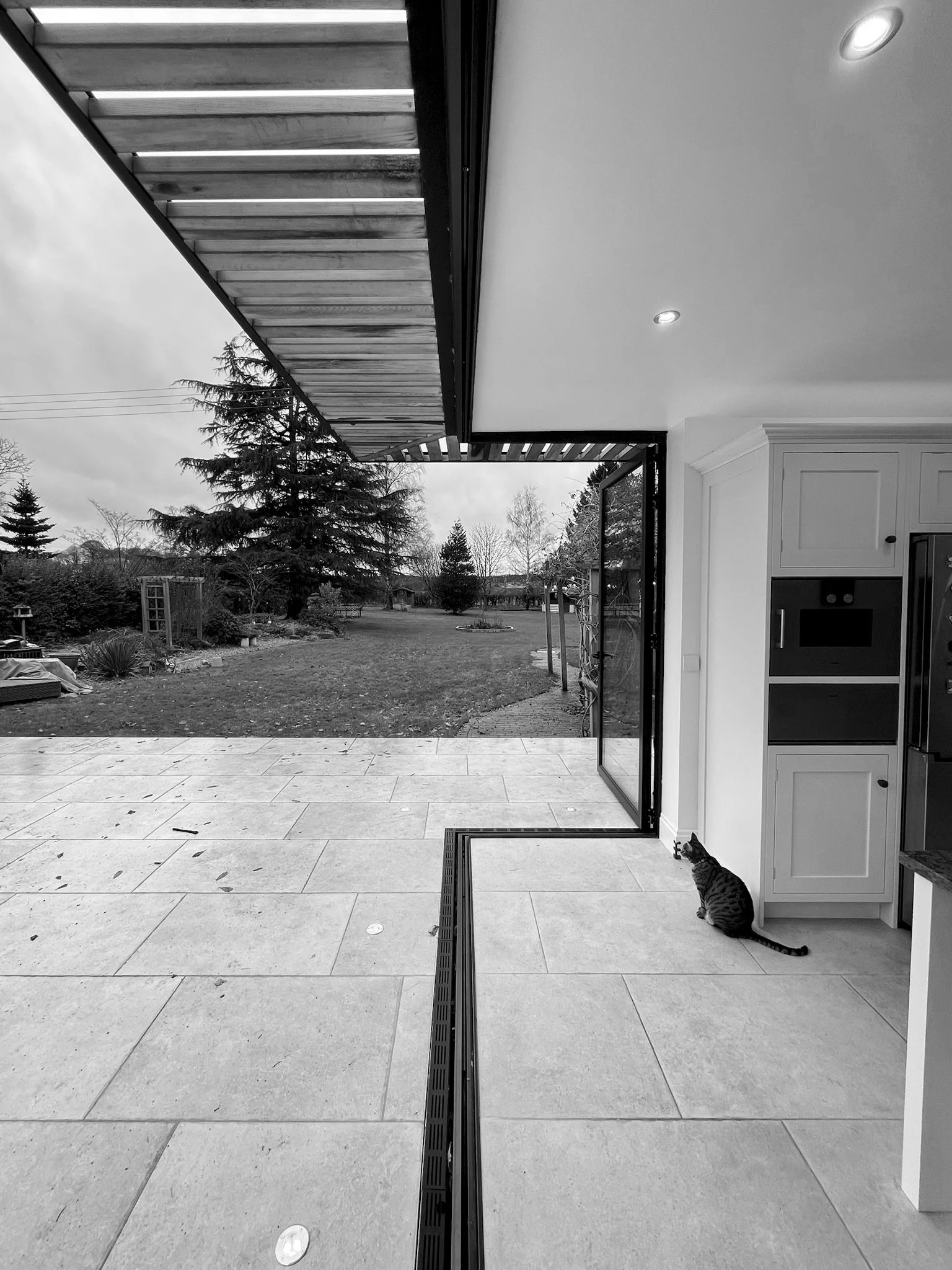 Cantilevered bifolding corner door with solar shading, level threshold external paving