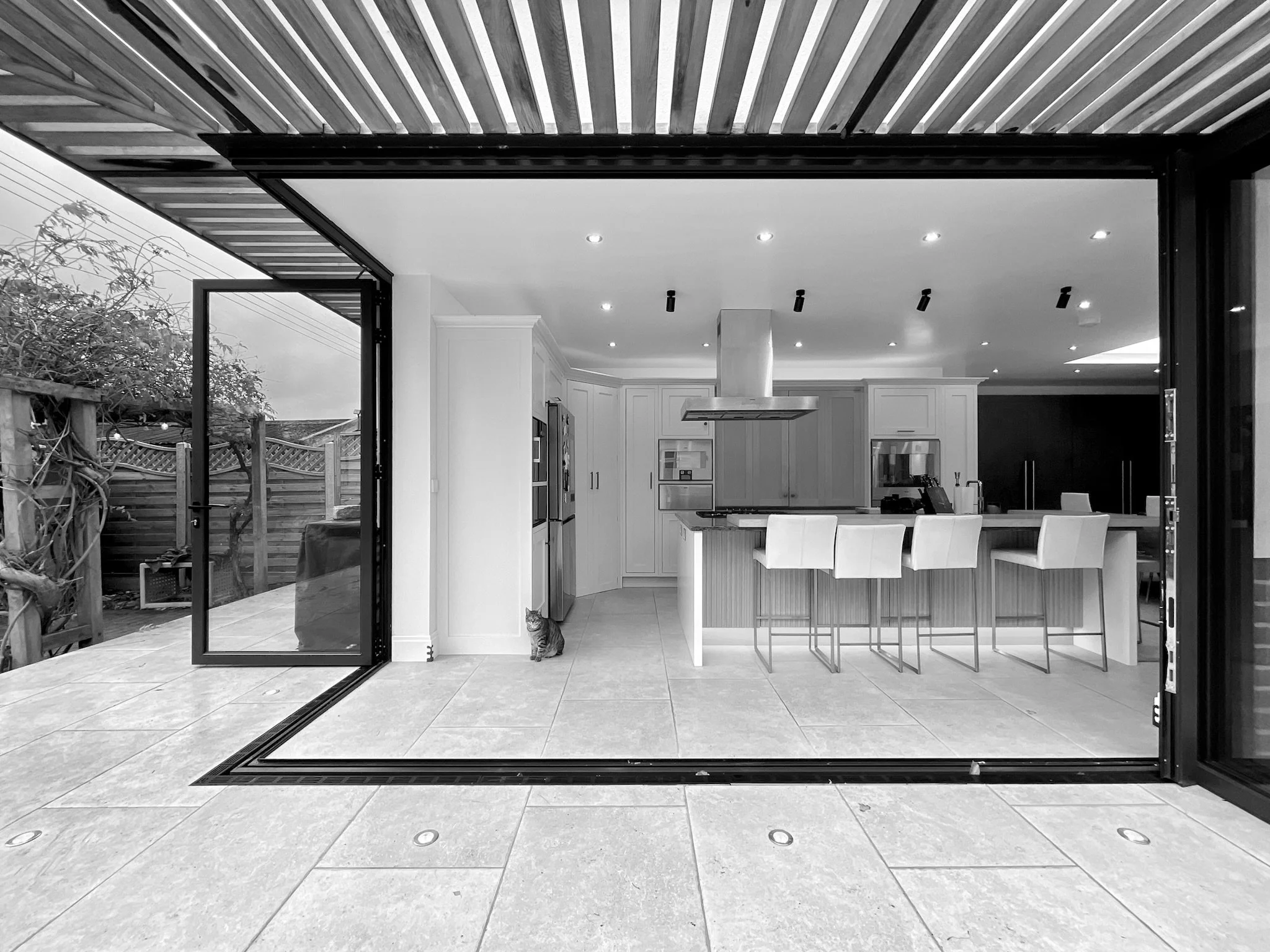 Bifolding cantilevered corner door opening kitchen diner with hit and miss timber solar shading
