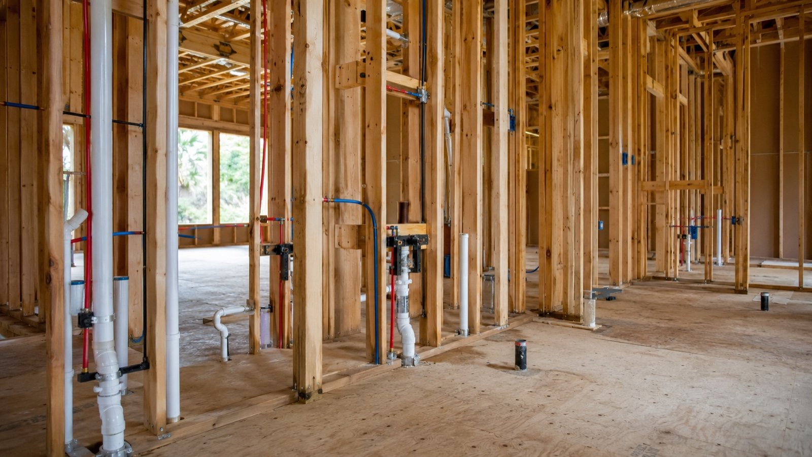 Custom home under construction with plumbing roughed into open framed walls