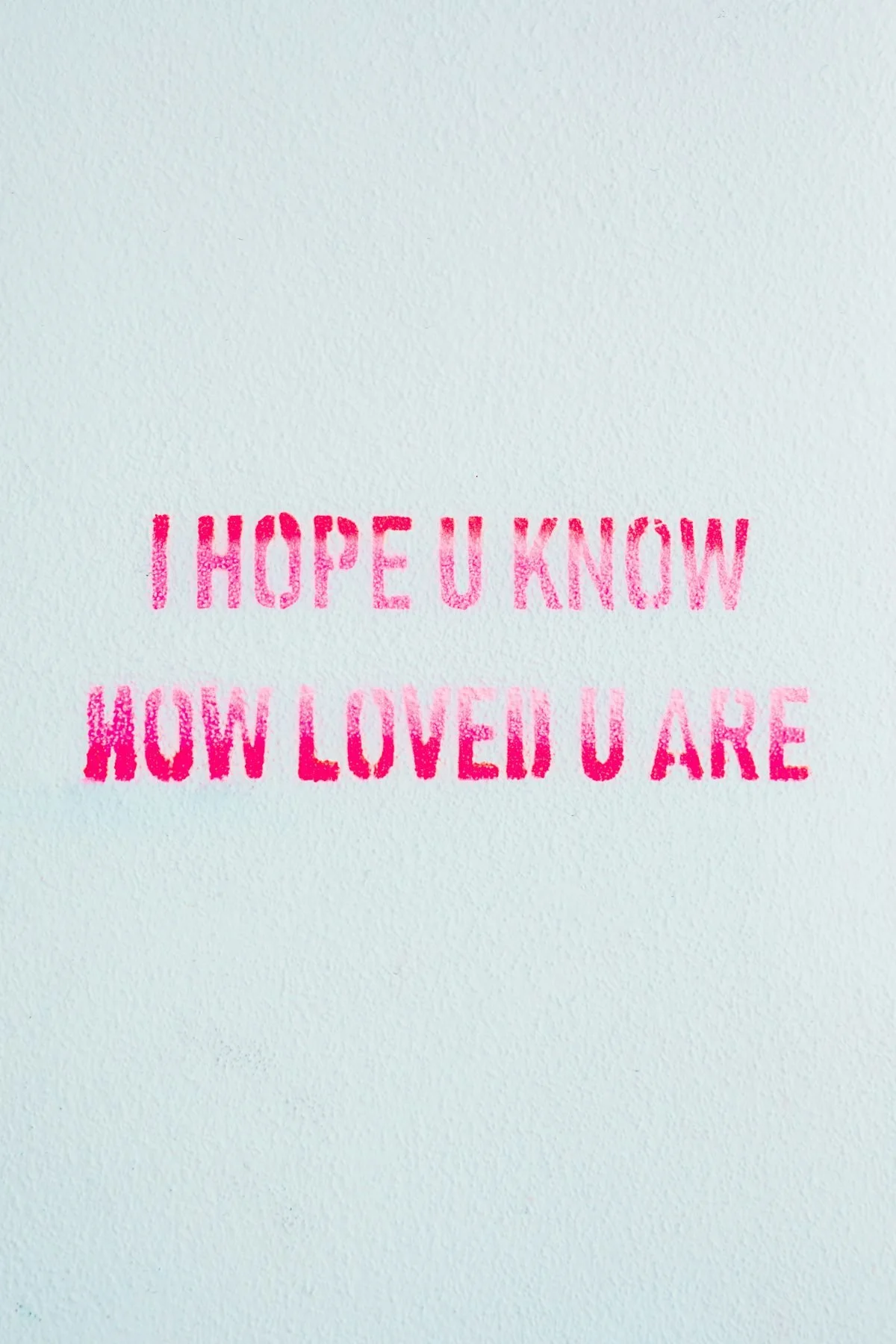 Pink stamped message on white background reading "I HOPE U KNOW HOW LOVED U ARE".