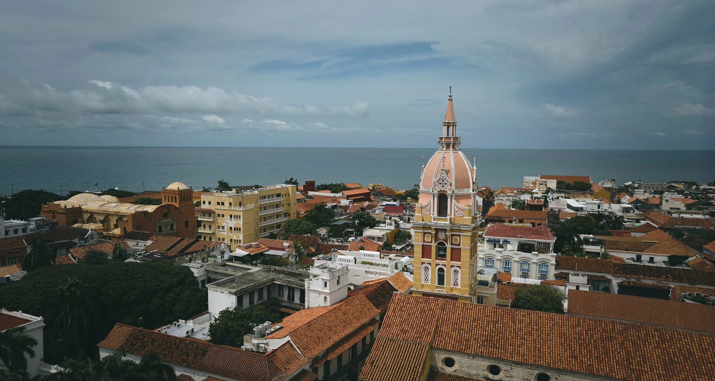 Aerial view of a coastal town with a cathedral dome and tiled roofs
