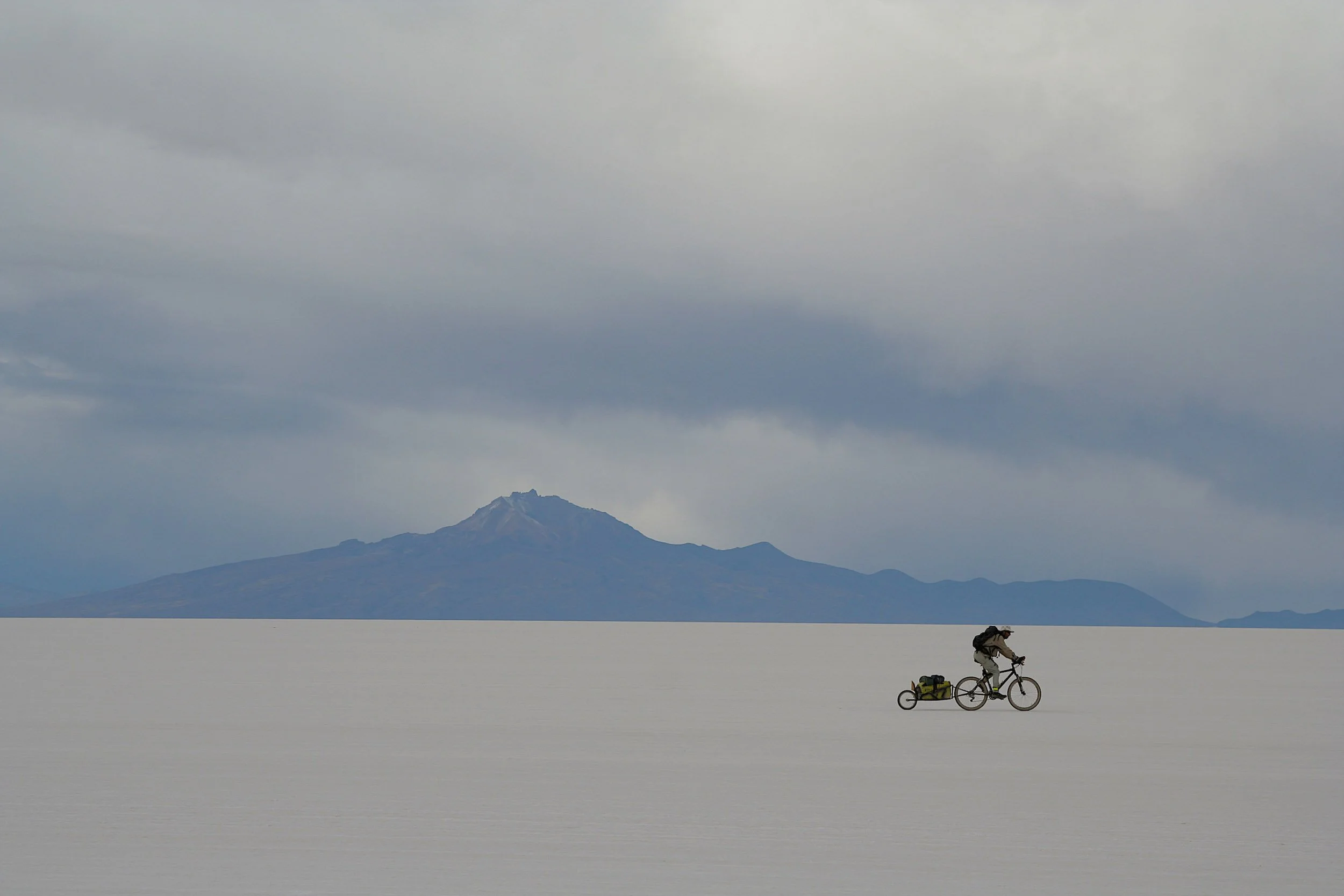 Cyclist with touring gear riding a coastal mountain road