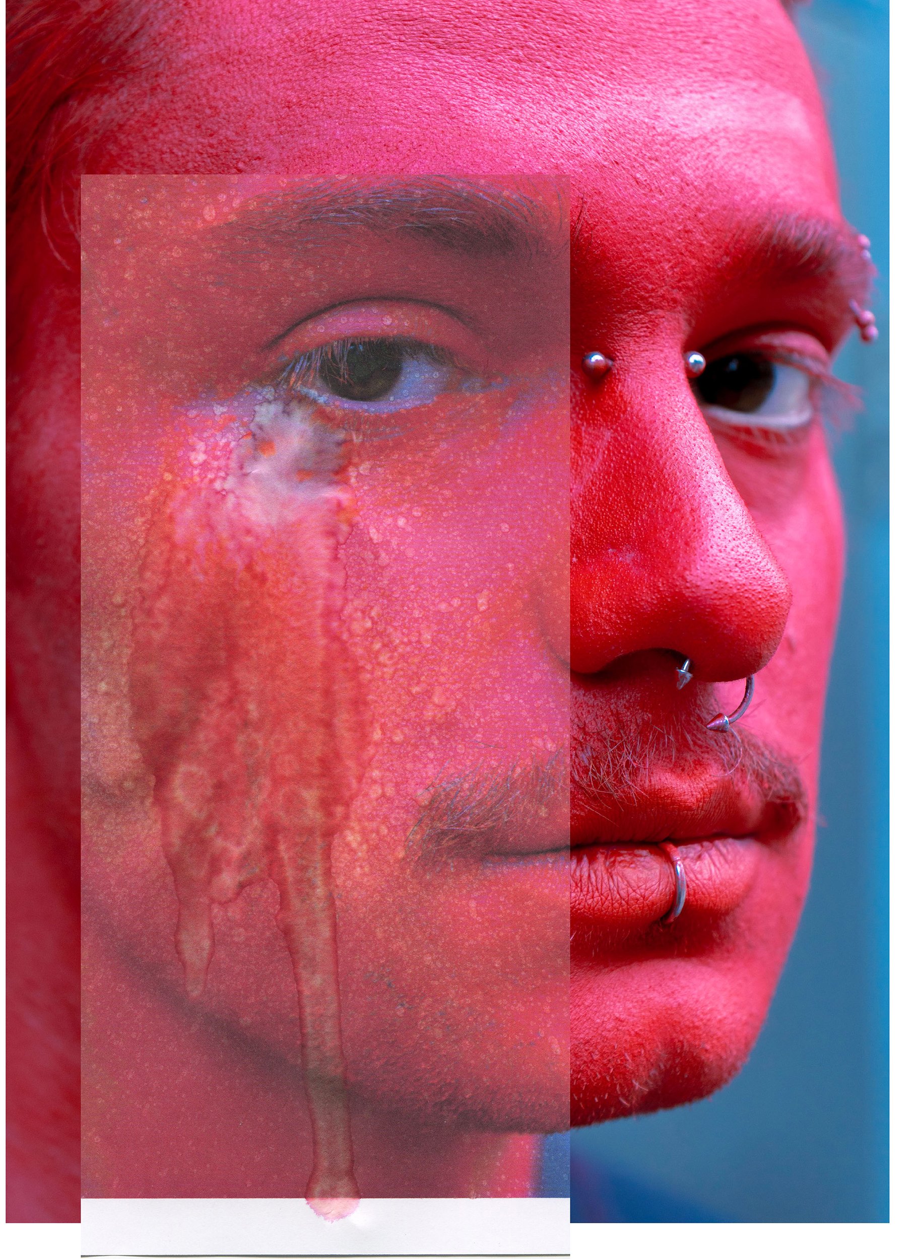 Close-up of a person's face with bright pink makeup on the skin, eyebrows, and lips, and multiple facial piercings including nose and lip piercings.