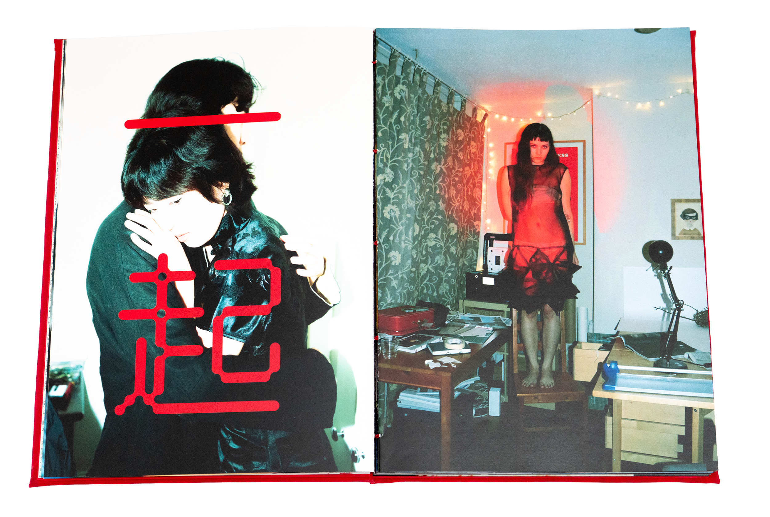 Open magazine showing a photo of a woman with black hair in a black outfit on the left page, and a woman in a red sheer dress with black hair standing in a room decorated with string lights on the right page.
