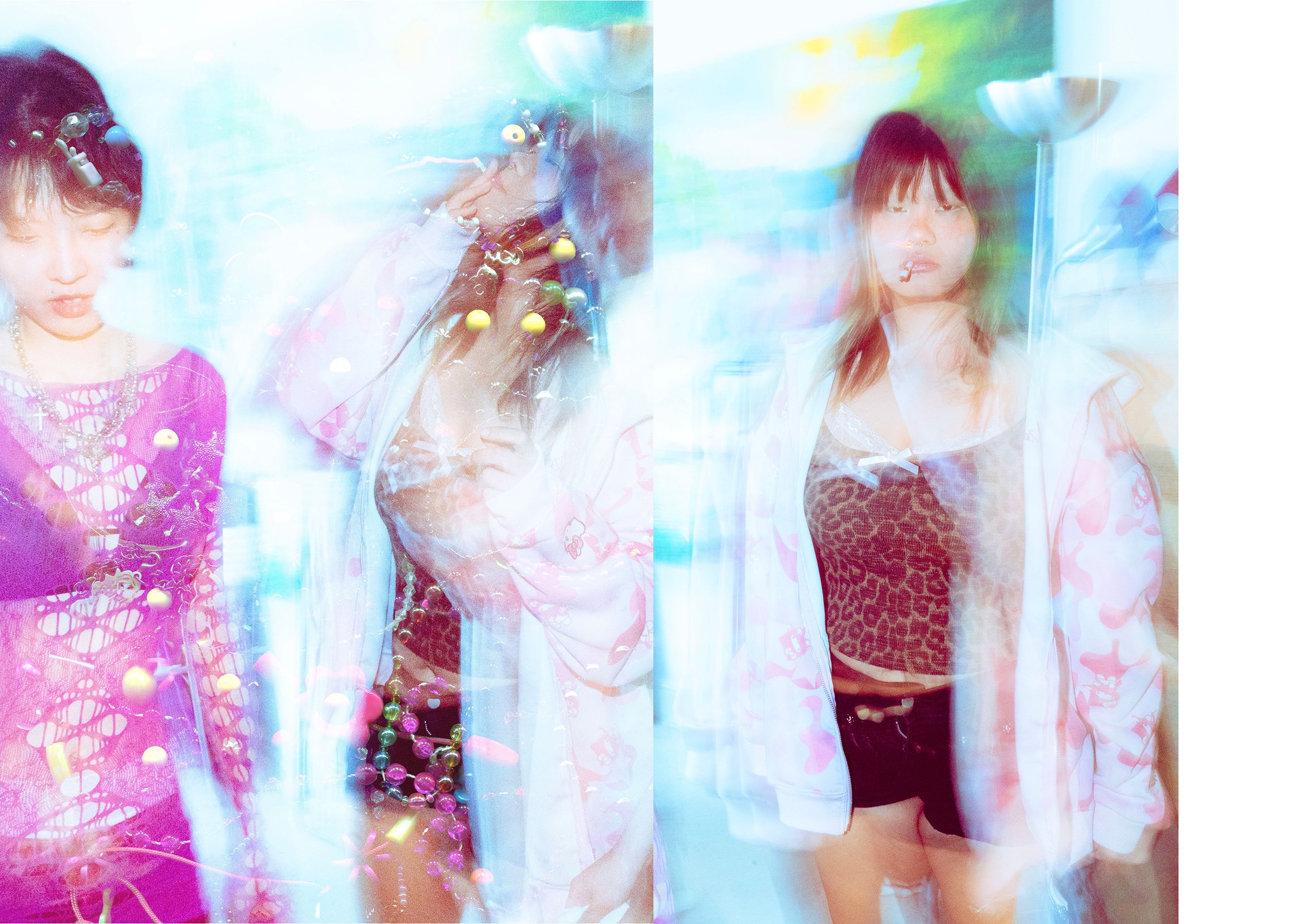 Two women standing in front of a colorful, abstract background. One on the left wearing a purple top with patterns and jewelry, the other on the right wearing a white jacket with animal print top and shorts. Both appear to be at a party or event, with a playful, artistic atmosphere.