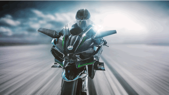 A person riding a black and green sport motorcycle on a road with blurred background and sky.