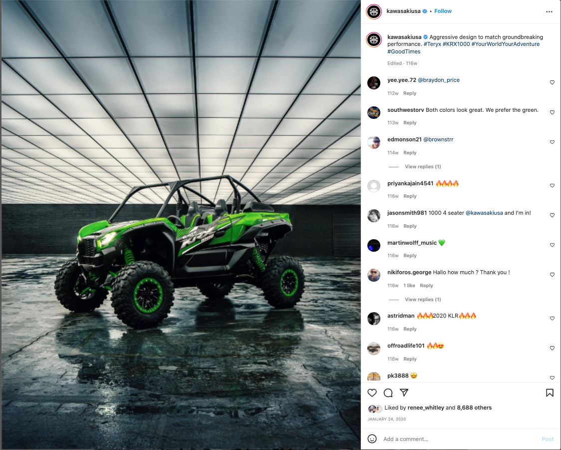 A green and black off-road vehicle with four seats and large tires, parked on a wet surface inside a modern, enclosed space with a grid-patterned ceiling.
