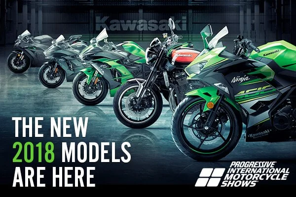 Four Kawasaki motorcycles lined up indoors at a motorcycle show, with promotional text indicating the 2018 models are present at the Progressive International Motorcycle Shows.