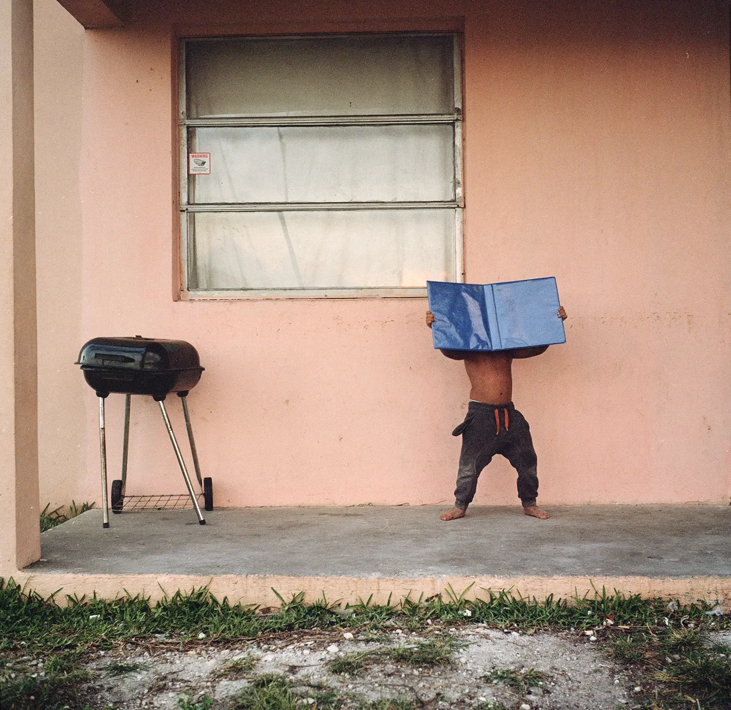 Angie's son plays on the porch of the motel they lived in for some months.