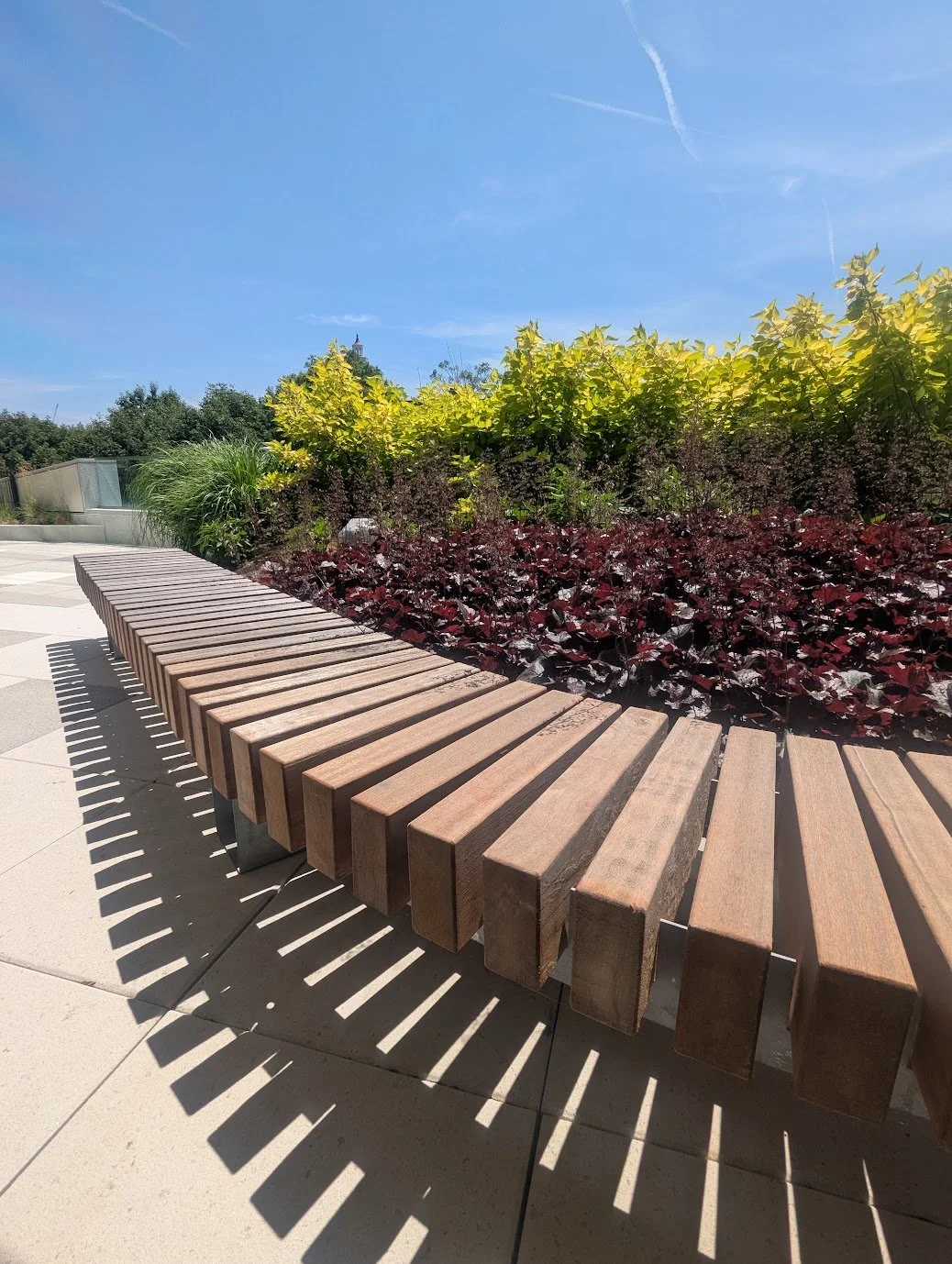 Architectural detail of an outdoor bench with repeating pattern in the shadow