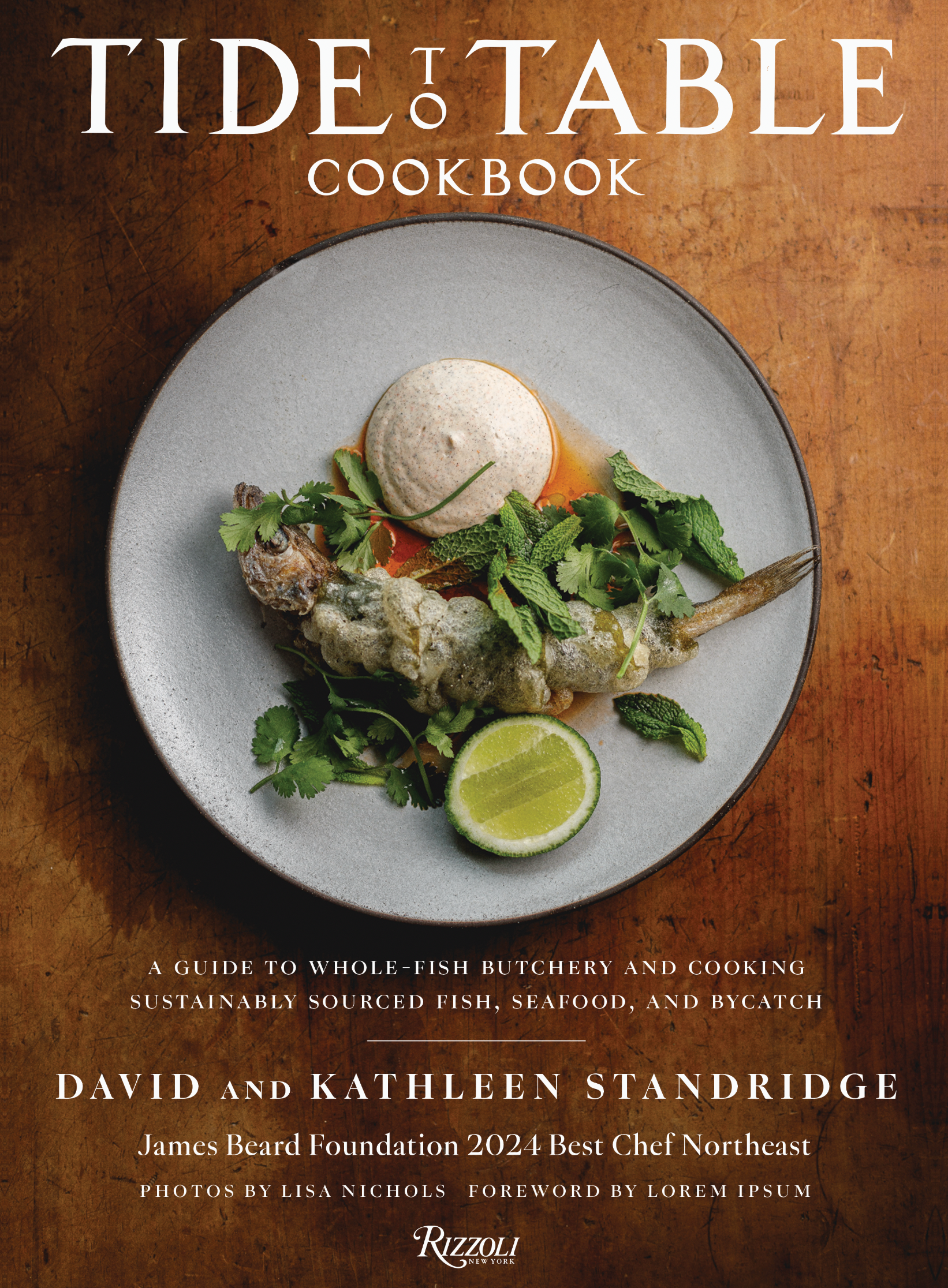 Cover of a cookbook titled "TIDE: TABLE" featuring a dish with fish, herbs, lime, and a dollop of sauce or mousse on a gray plate with a wooden background.