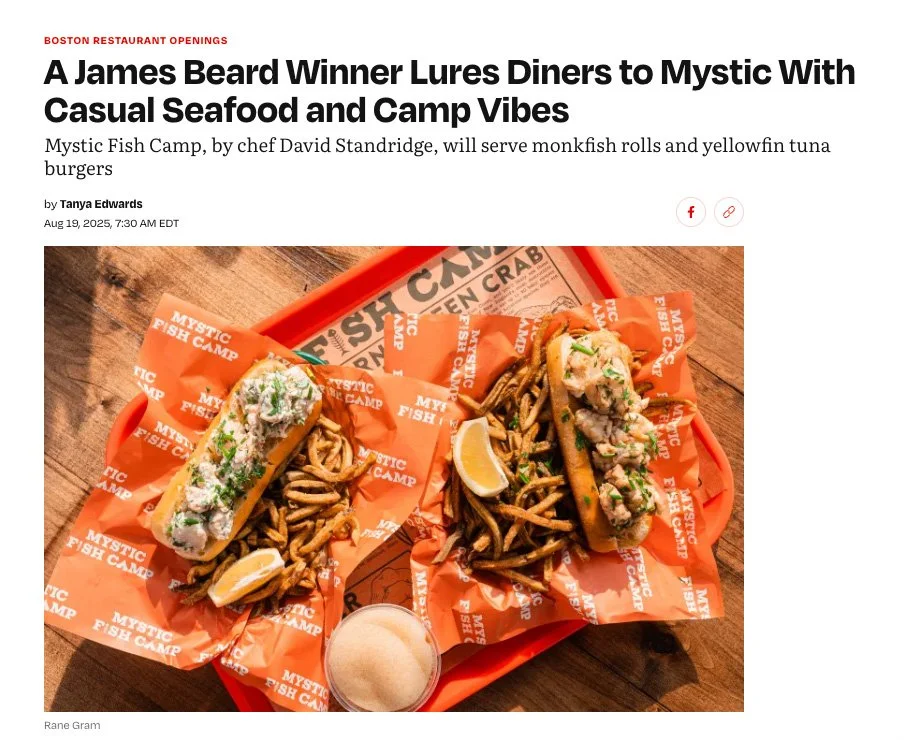 Two seafood sandwiches served on orange paper with curly fries, lemon wedges, and a small cup of dipping sauce on an orange tray from Eater featuring Mystic Fish Camp