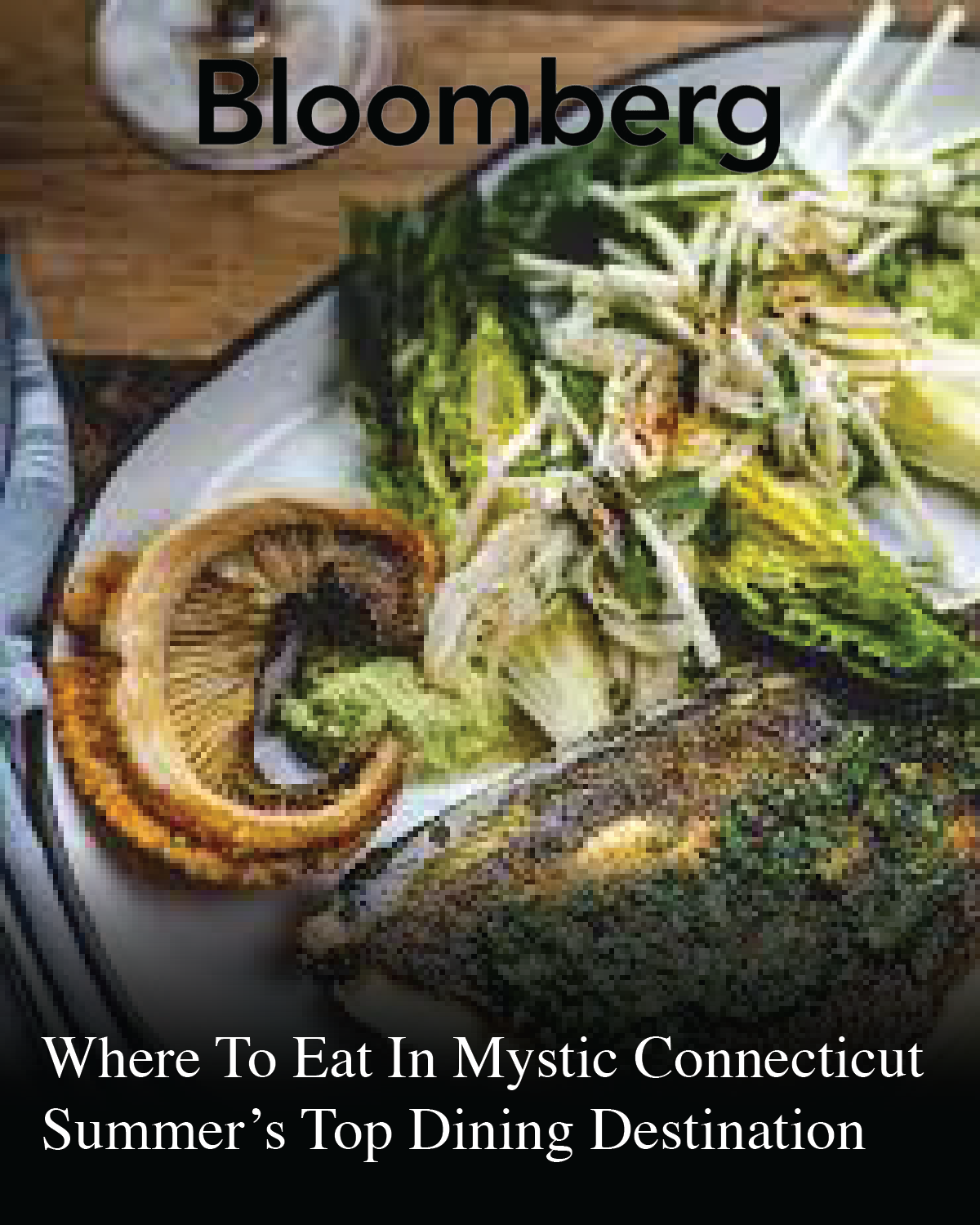 A plate of food with grilled lemon and a salad with greens and vegetables. The image is overlaid with the text 'Bloomberg' and a headline about dining destinations like The Shipwright's Daughter in Mystic, Connecticut.