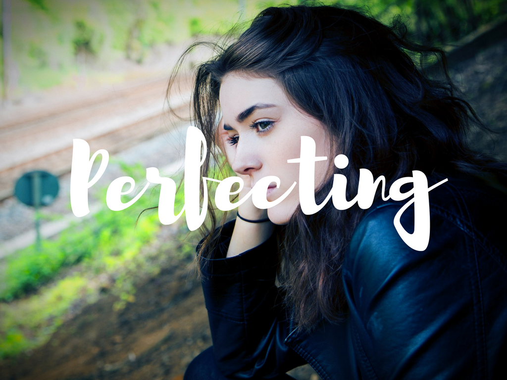 woman looking into distance with the word perfecting from trauma therapist sacramento