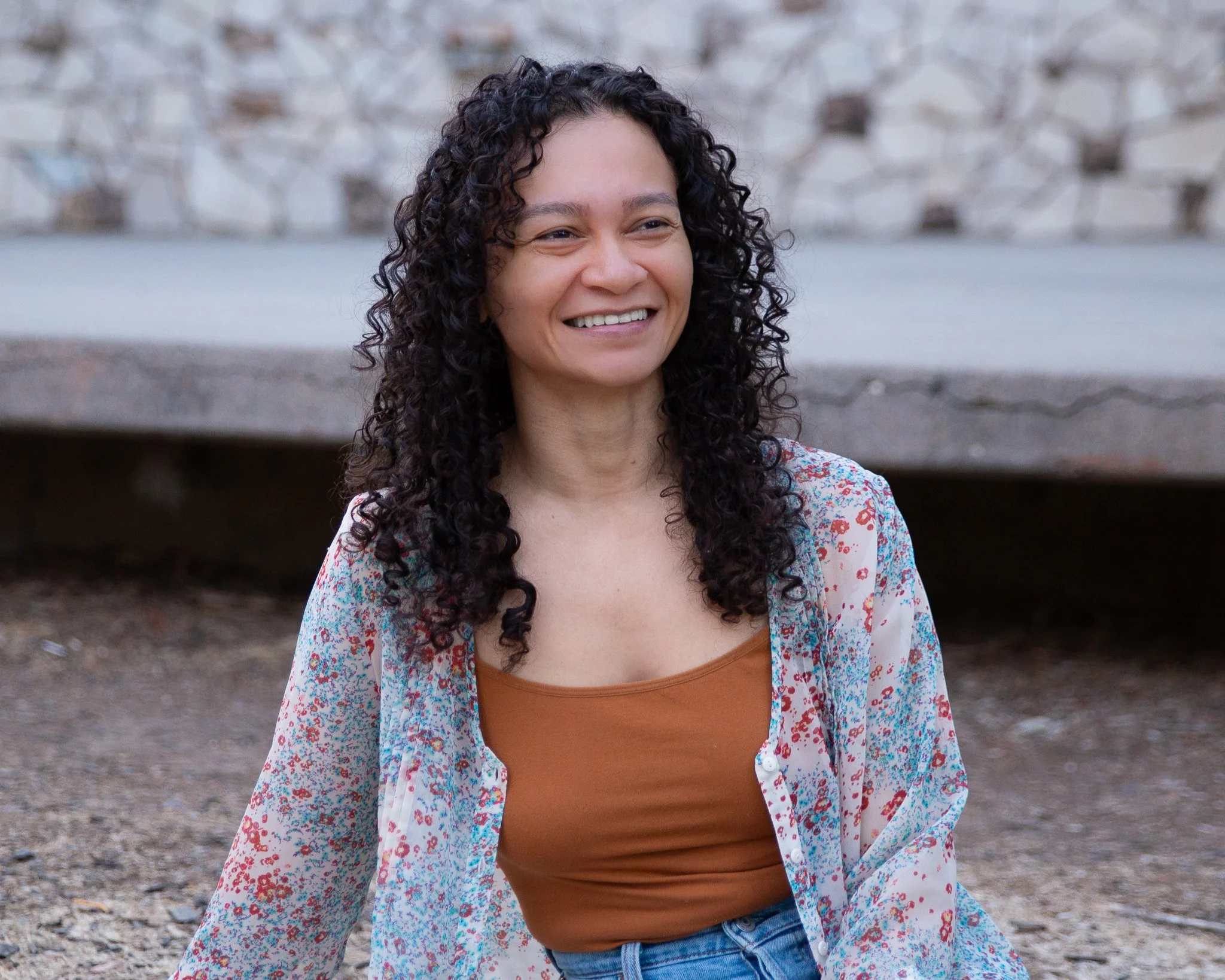 curly haired woman smiling she is a trauma therapist sacramento