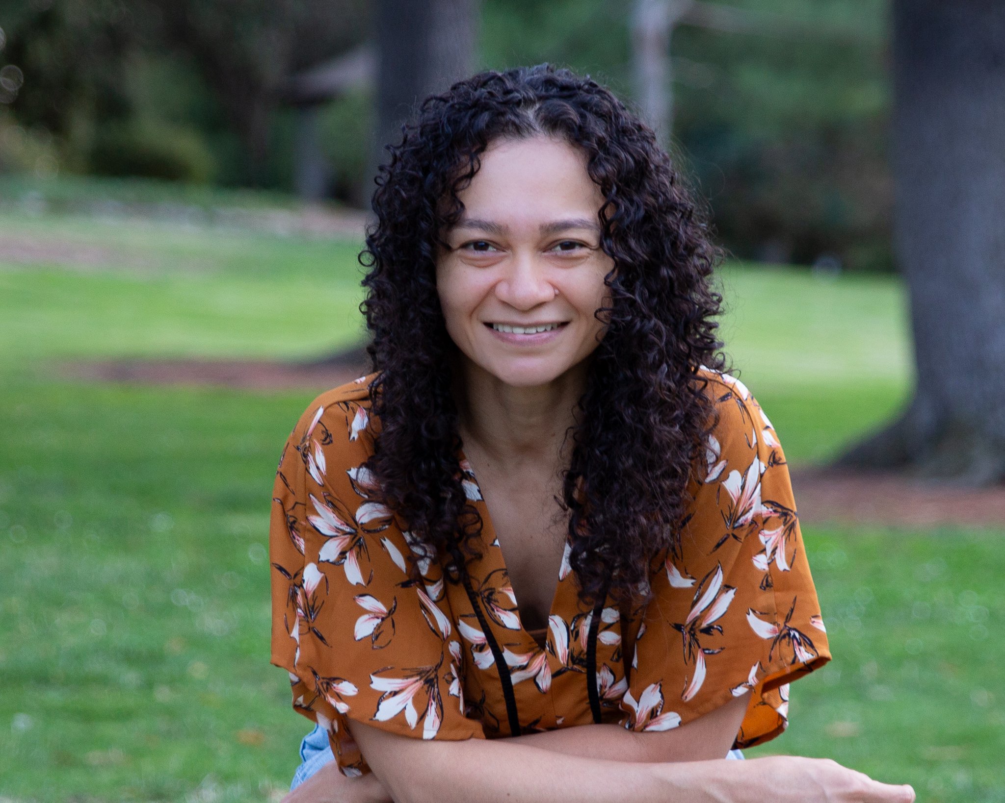 woman in yellow floral top smiling. she is a trauma therapist sacramento with self-worth specialty