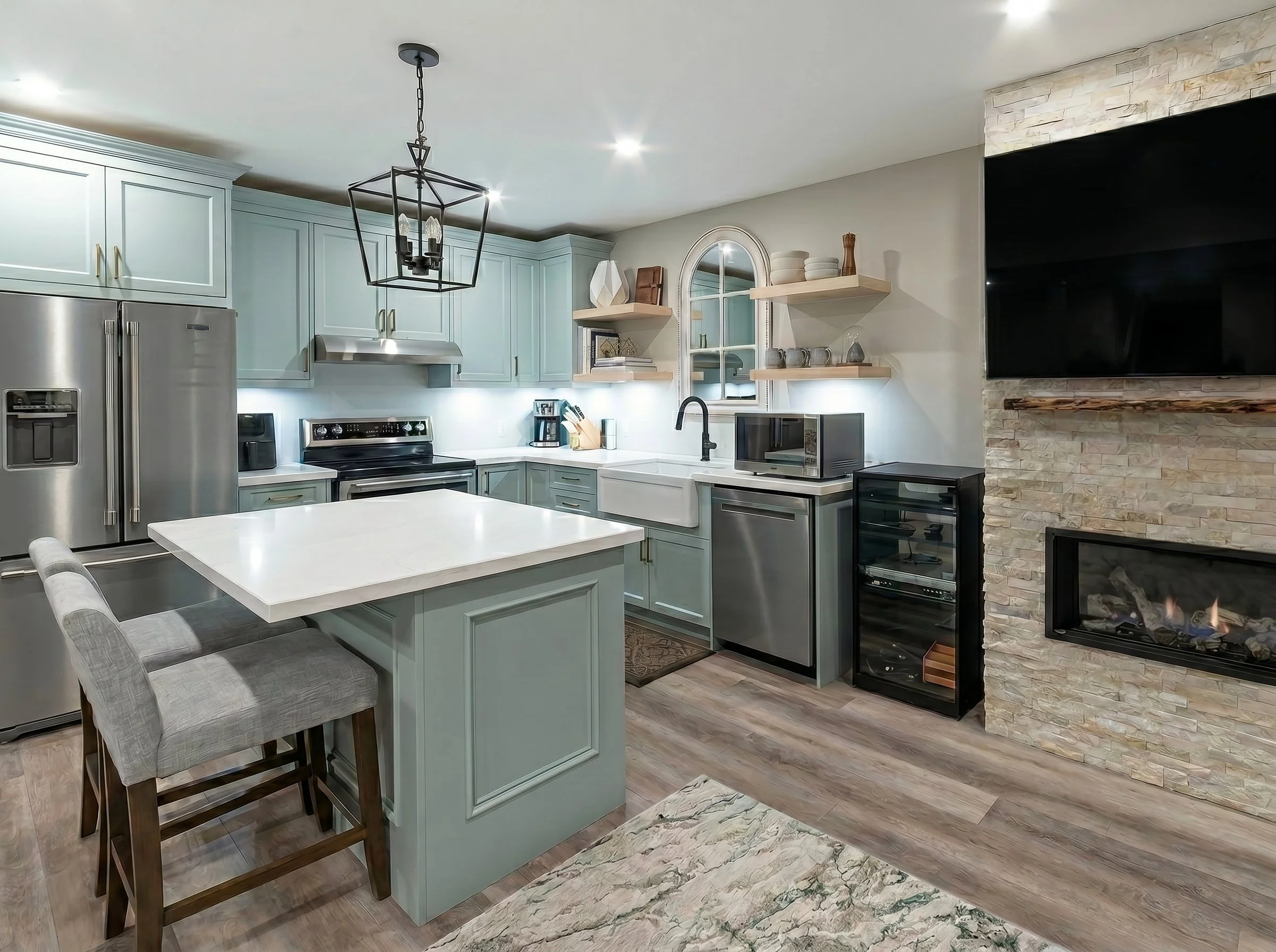Bright open-concept basement featuring the custom kitchen, fireplace and entertaining space.